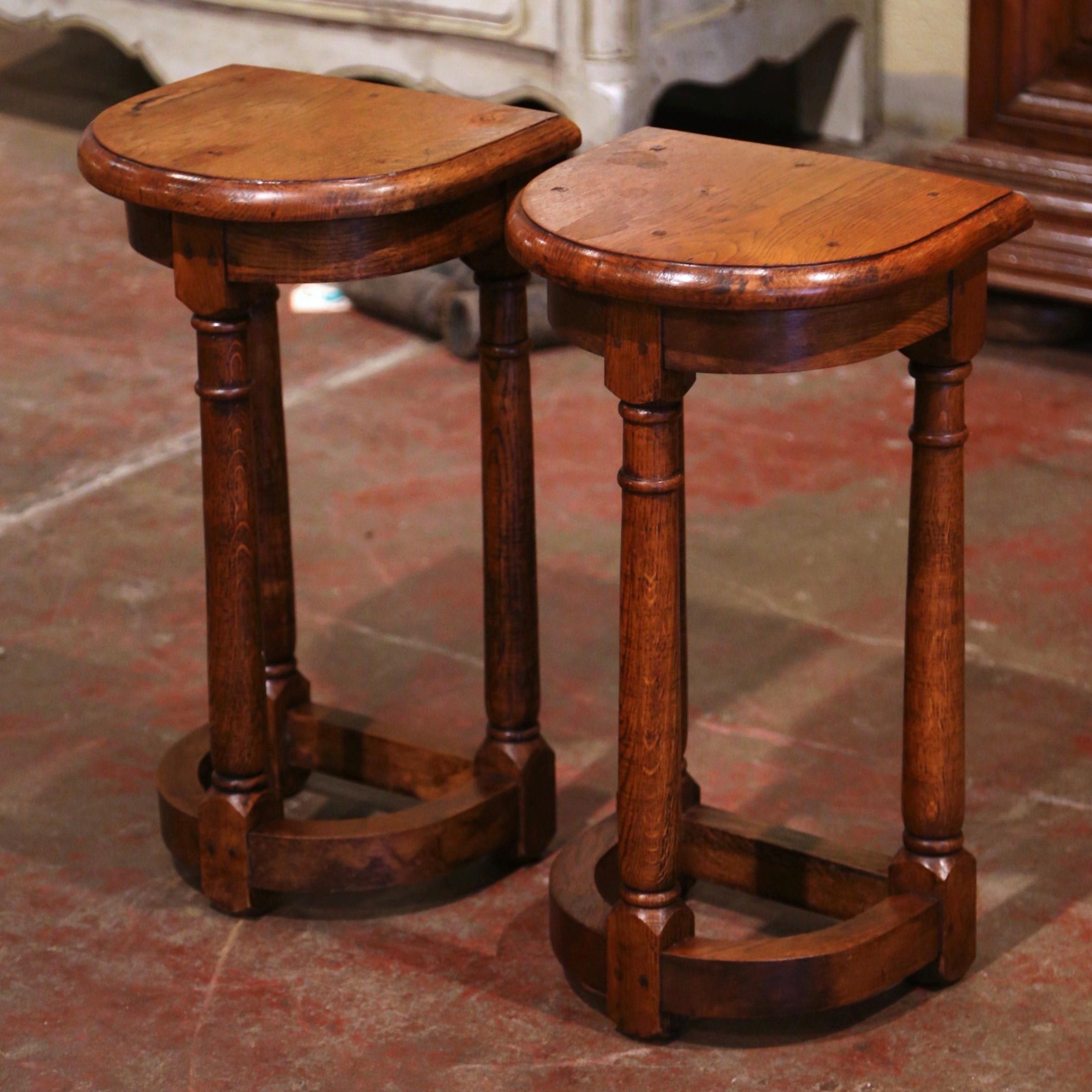 Crafted in the North of France circa 1880 and shaped as half moon, each antique table stands on three elegant turned legs connected with a bottom stretcher. Both tall tables are in excellent condition commensurate with age and use, and adorn a rich