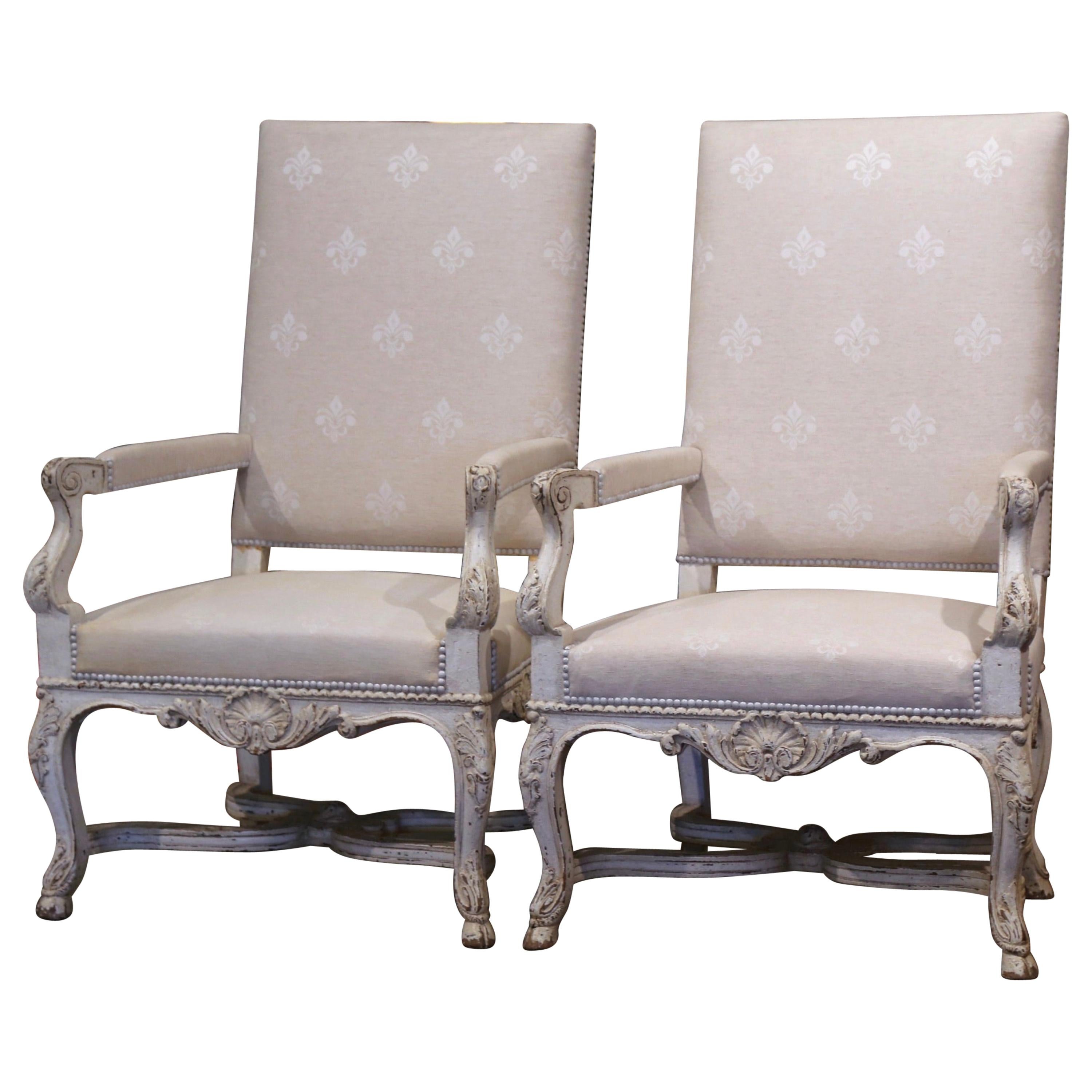These elegant antique armchairs were crafted in France, circa 1870. Each large fauteuil stands on cabriole legs ending with hoof feet over an intricate curved bottom stretcher embellished by a middle carved floral medallion; it is further decorated
