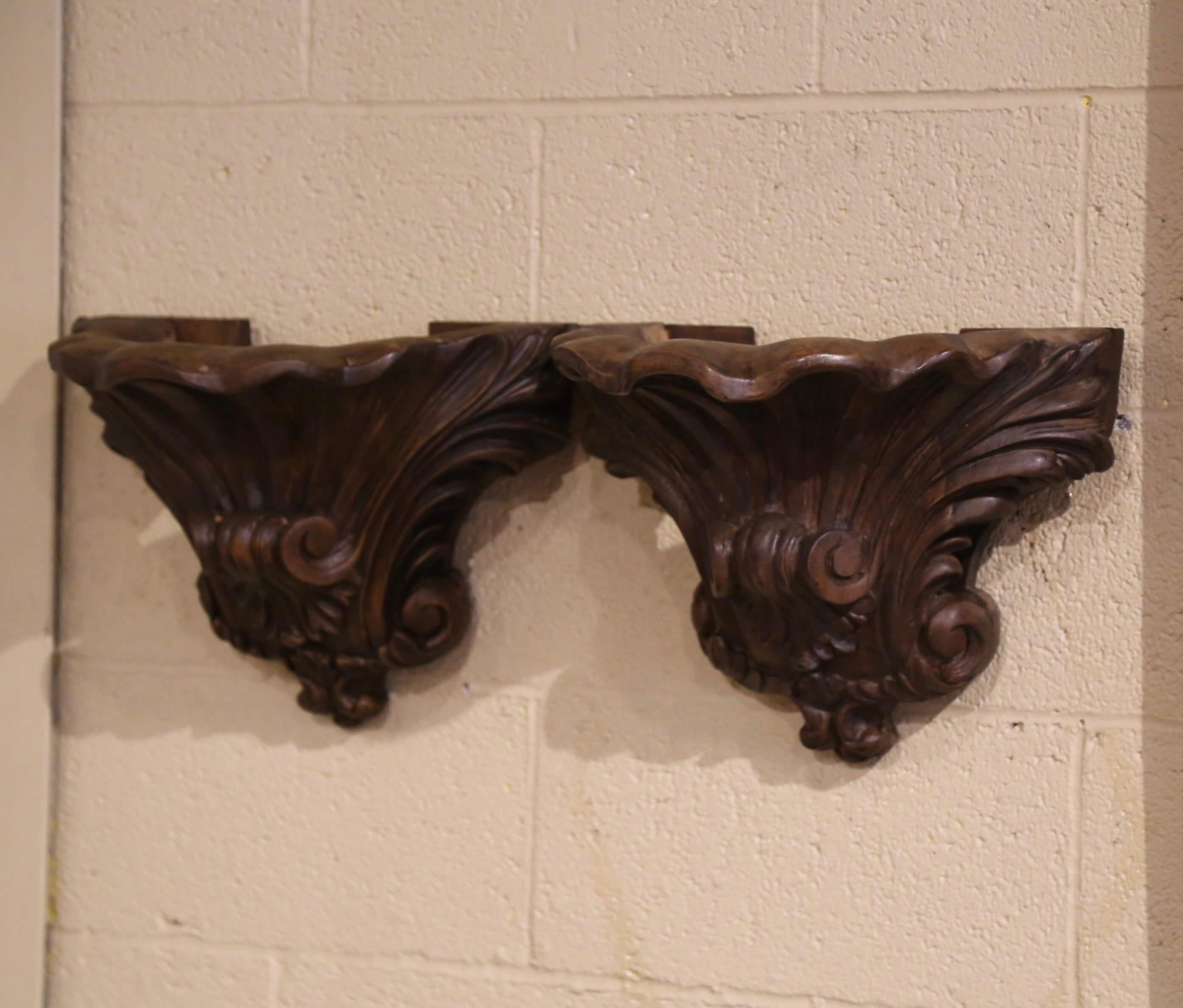 Décorez un mur avec cette élégante paire de corbeaux en noyer ancien. Fabriqué dans le sud de la France, vers 1860, chaque support mural en bois fruitier présente un motif rappelant l'ornementation classique ou rococo, souvent présente dans la