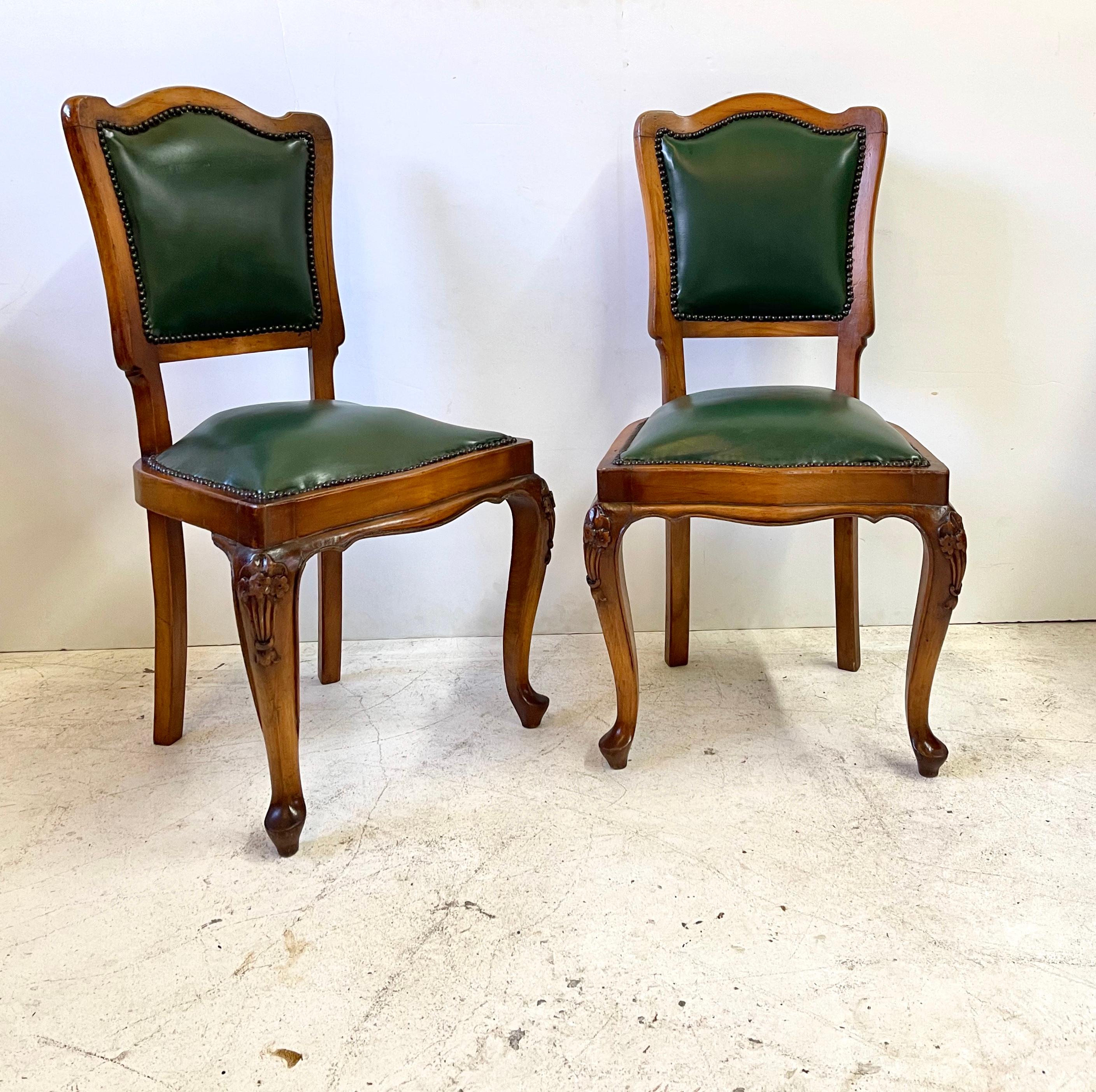Pair of 19th century Italian side chairs in the style of Louis XV with fruitwood frames, solid wood backs, and beautifully carved cabriole legs. The chair seats and the backs are upholstered and lined with nailheads.