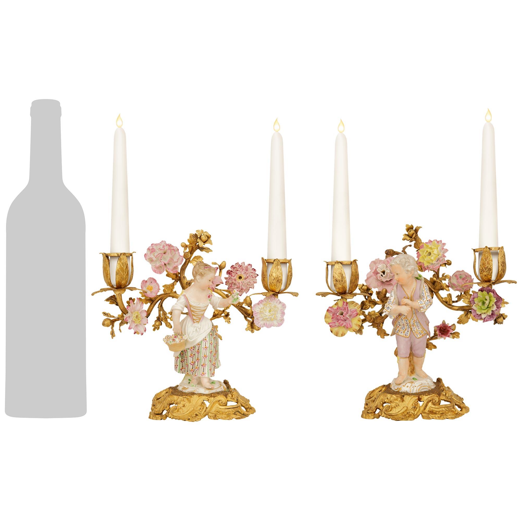 Una coppia affascinante e molto decorativa di candelabri continentali del XIX secolo in stile Luigi XV in Ormolu e Meissen Porcelain. Questa meravigliosa coppia è sollevata da basi in Ormolu arrotondate e traforate con disegni foliati a volute e
