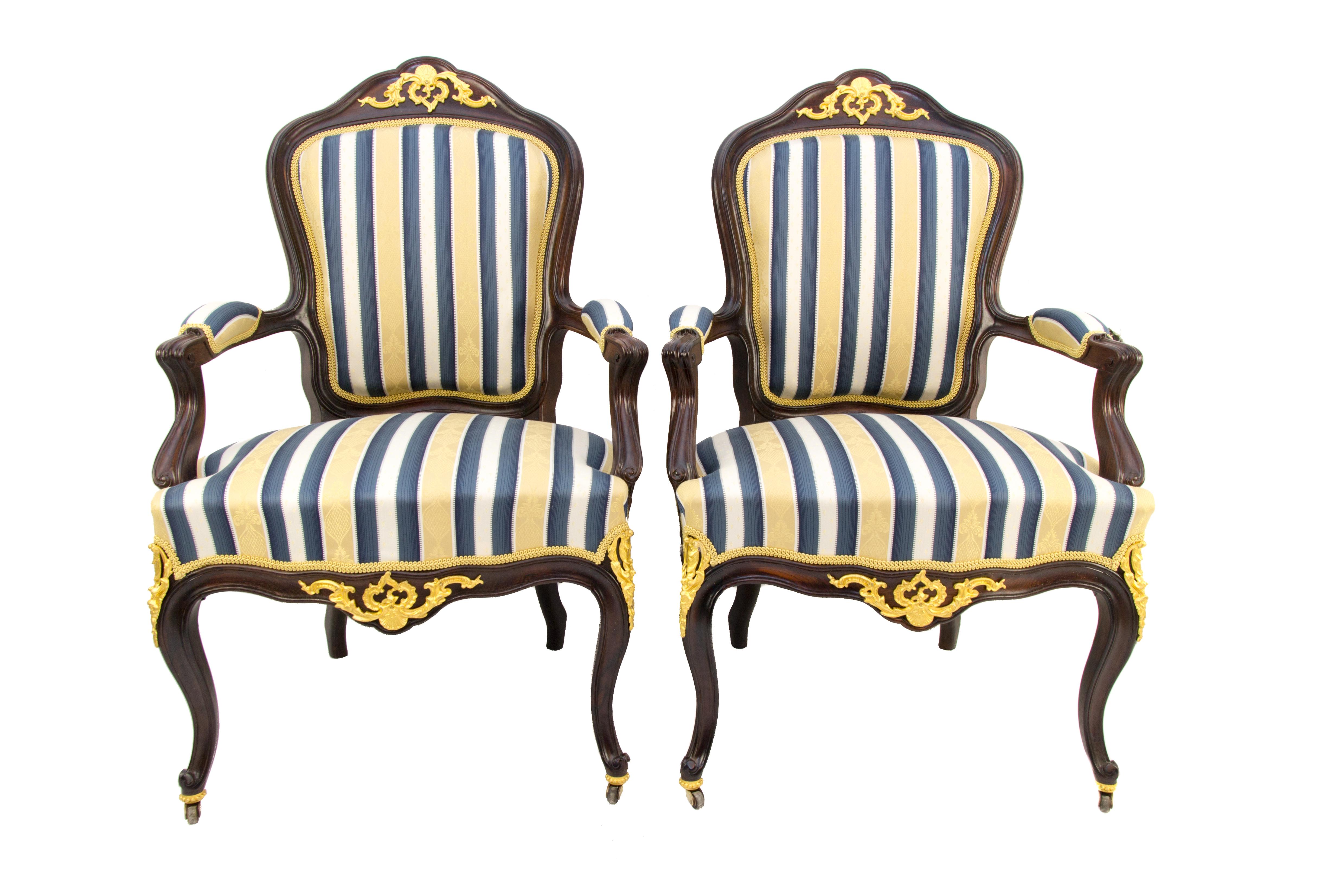 Pair of 19th Century Louis XV Style walnut and gilt bronze mounted armchairs with fabric in golden, blue, and white colors.
This impressive pair of Louis XV-style armchairs / Fauteuils from the late 19th century is made of walnut wood, with an