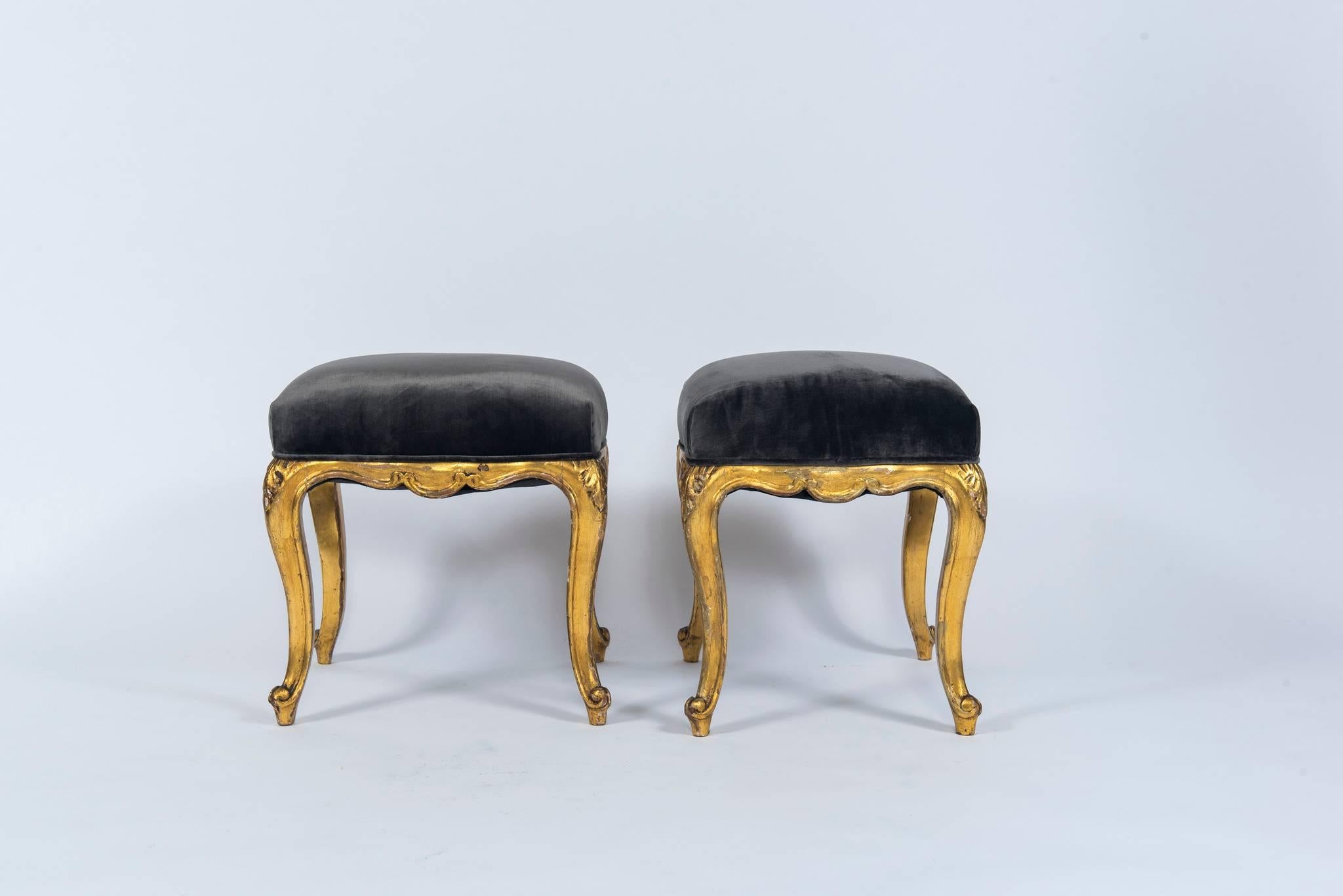 A pair of 19th century Louis XV style giltwood stools newly upholstered in a charcoal silk velvet.