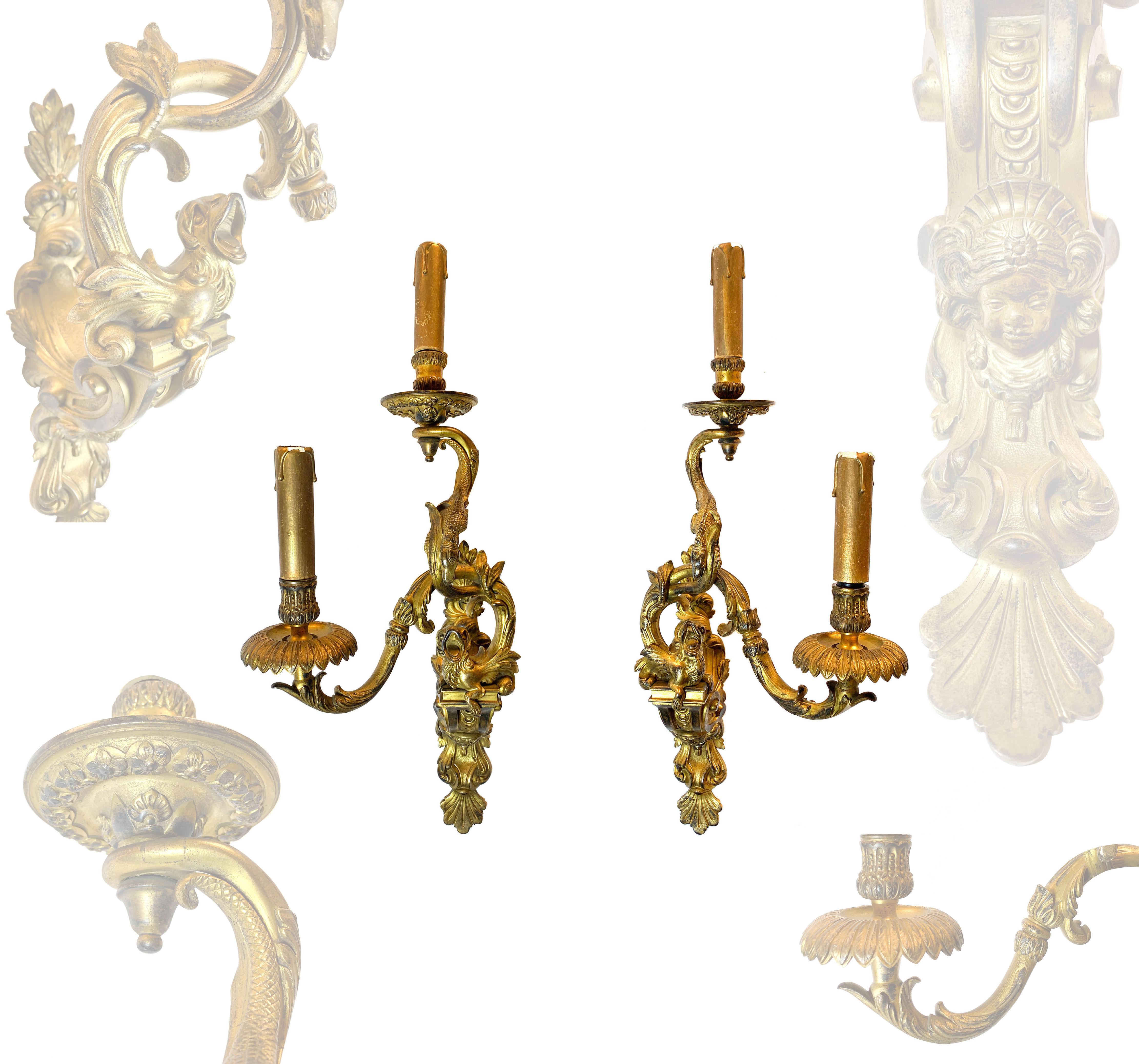A PAIR OF LOUIS XV STYLE ORMOLU TW0-BRANCH WALL-LIGHTS, 

AFTER A MODEL BY ANDRÉ-CHARLES BOULLE, 19TH CENTURY

Each with foliate-cast backplate surmounted by a dragon and a salamander, issuing assymetric foliate-sheathed candlebranches. 

H: