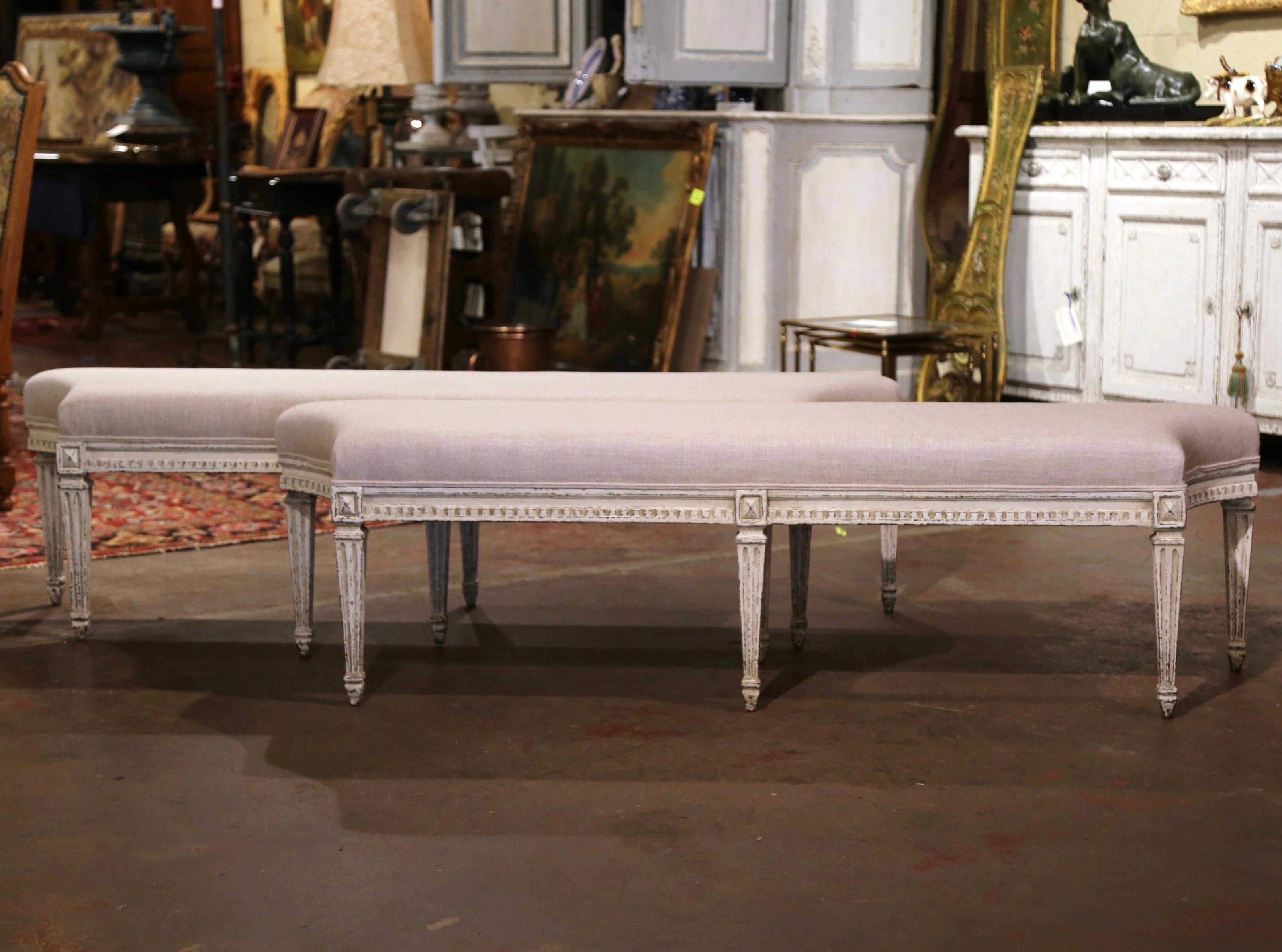 Complete your entryway or living room with this pair of antique painted benches. Crafted in France, circa 1890, each bench stands on six tapered and fluted legs decorated with diamond medallions at the shoulder. The seating features concave corners