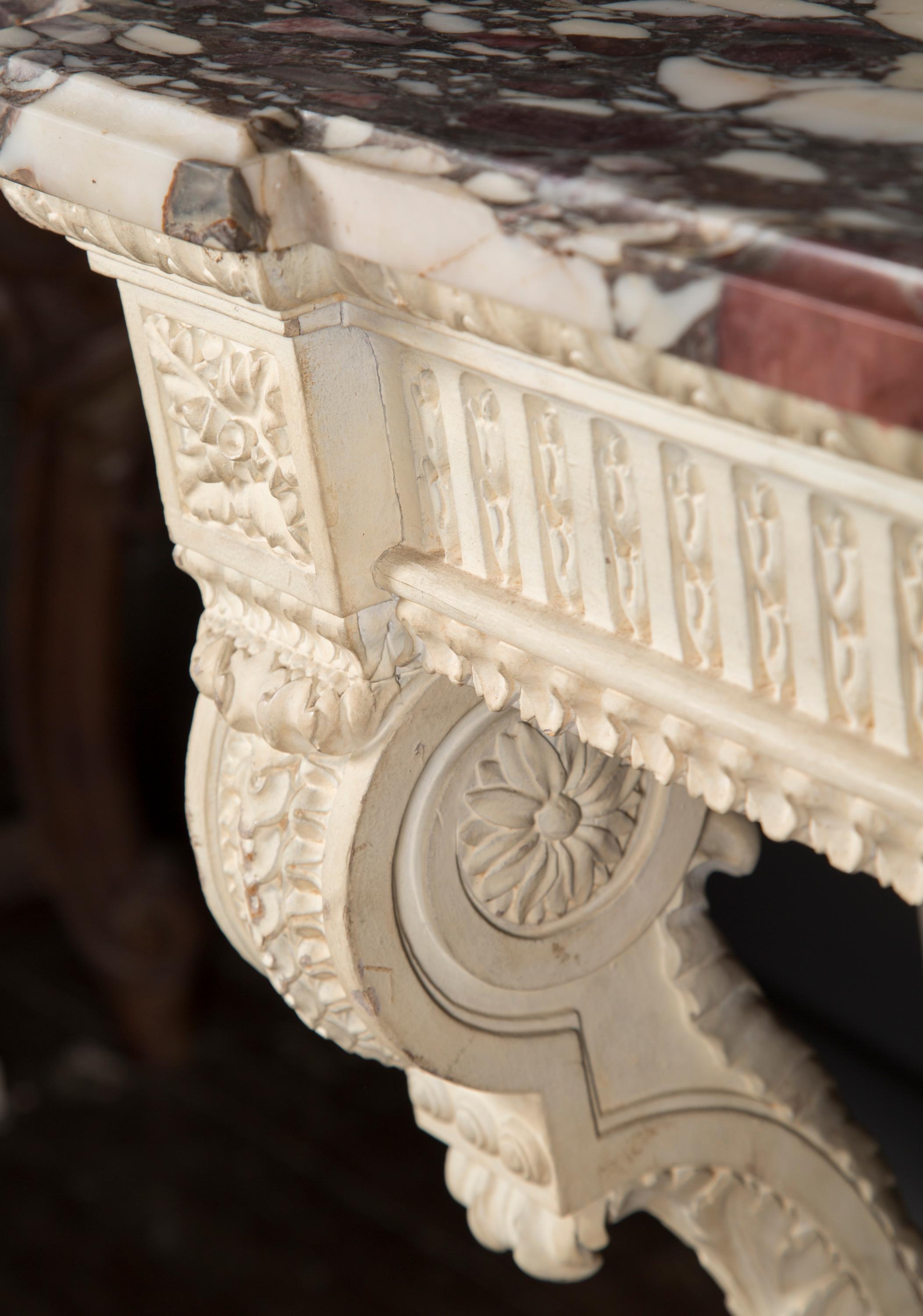 Este par de consolas Luis XVI del siglo XIX talladas y pintadas presentan, sobre todo, una tapa de precioso mármol breche de violette. Los fondos tallados a mano ofrecen detalles en abundancia; cada pata está adornada con hojas de acanto, con una