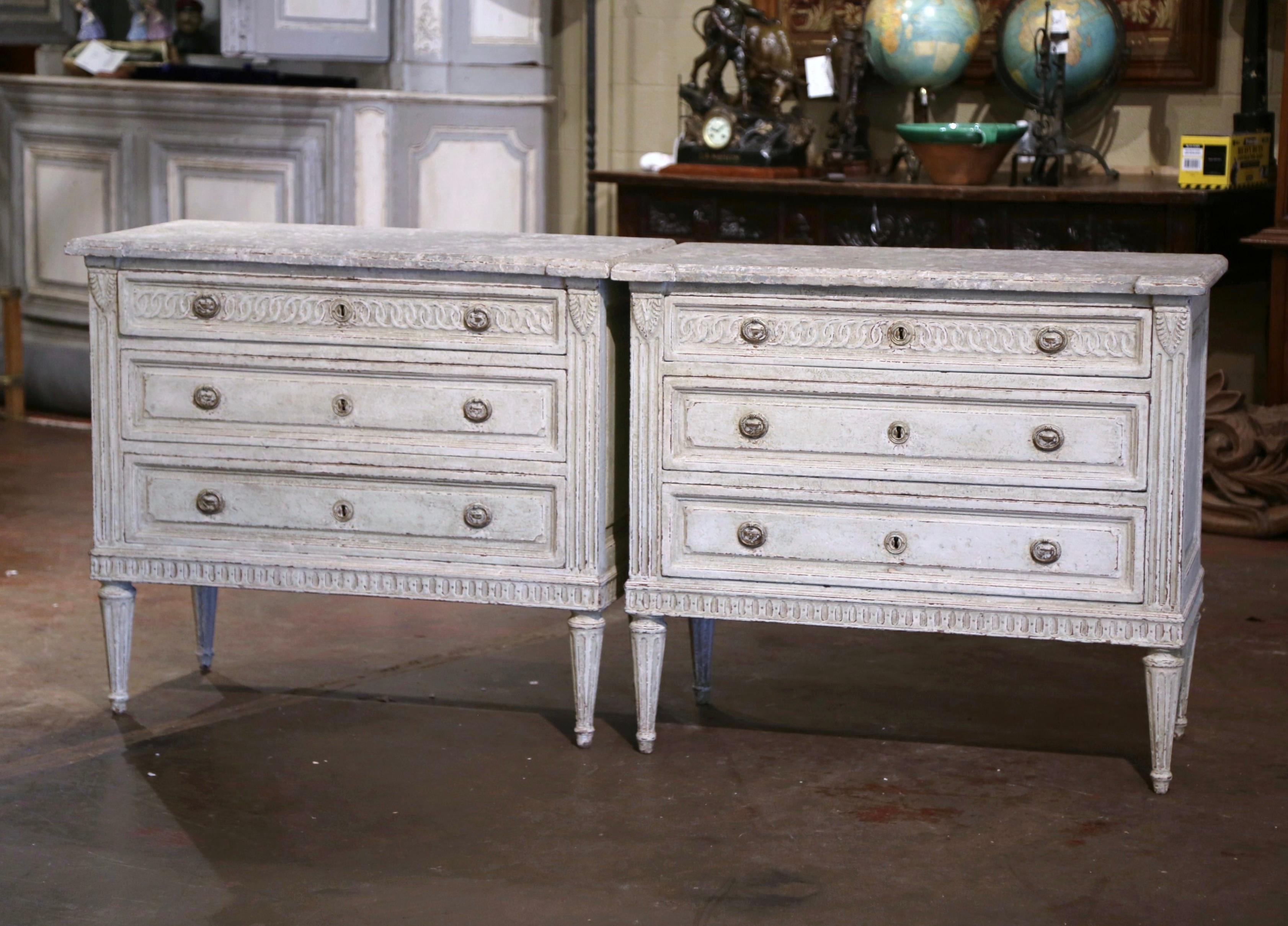 Utilisez cette élégante paire de commodes peintes à l'ancienne comme tables de chevet de chaque côté d'un grand lit, ou placez-les dans une entrée ou un salon. Fabriquée en France vers 1870, chaque commode repose sur des pieds fuselés et cannelés