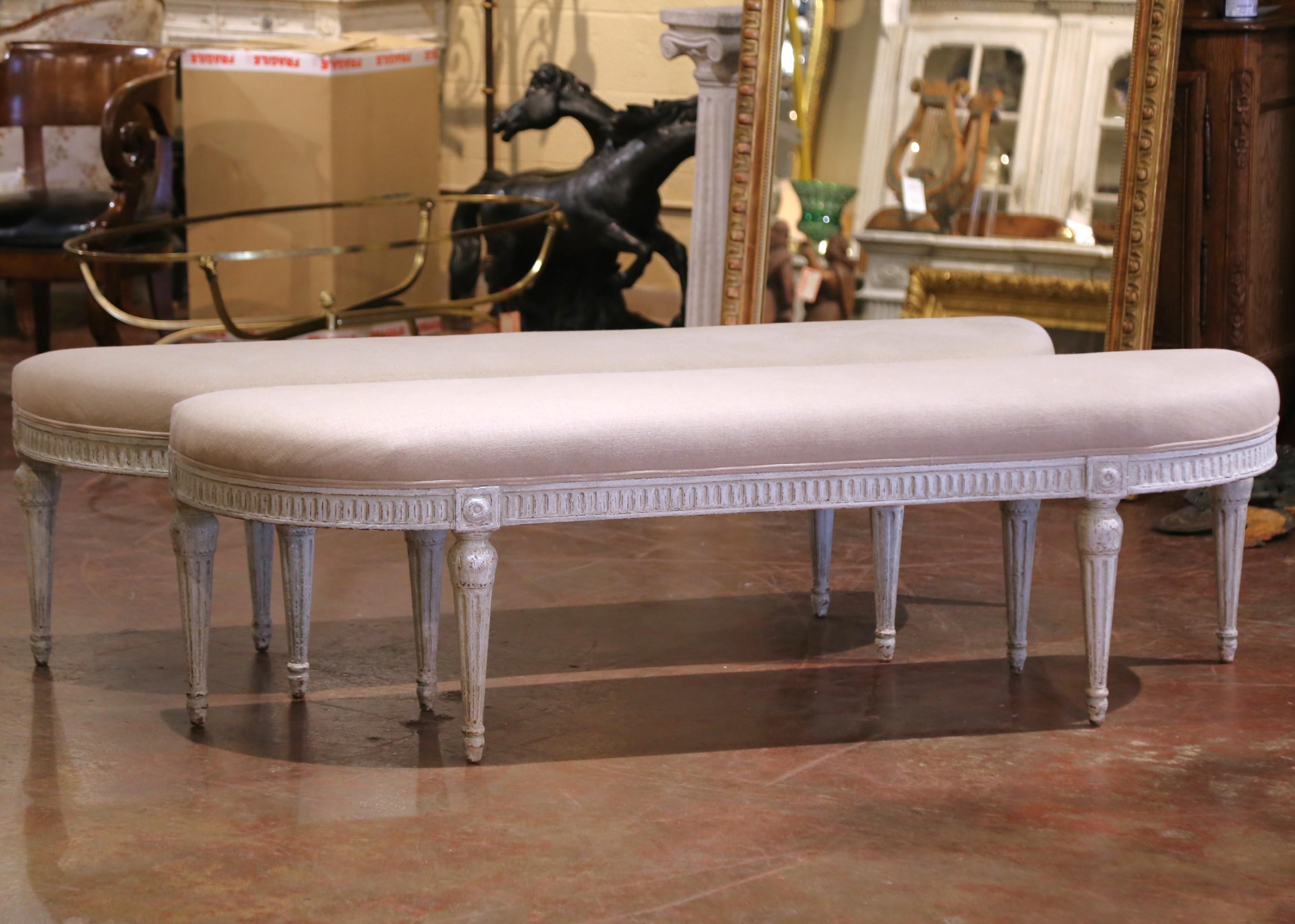 Complete your entryway or living room with this elegant pair of antique painted benches. Crafted in France, circa 1890 and built of beech wood, each bench stands on six tapered and fluted legs decorated with floral medallions rosettes at the