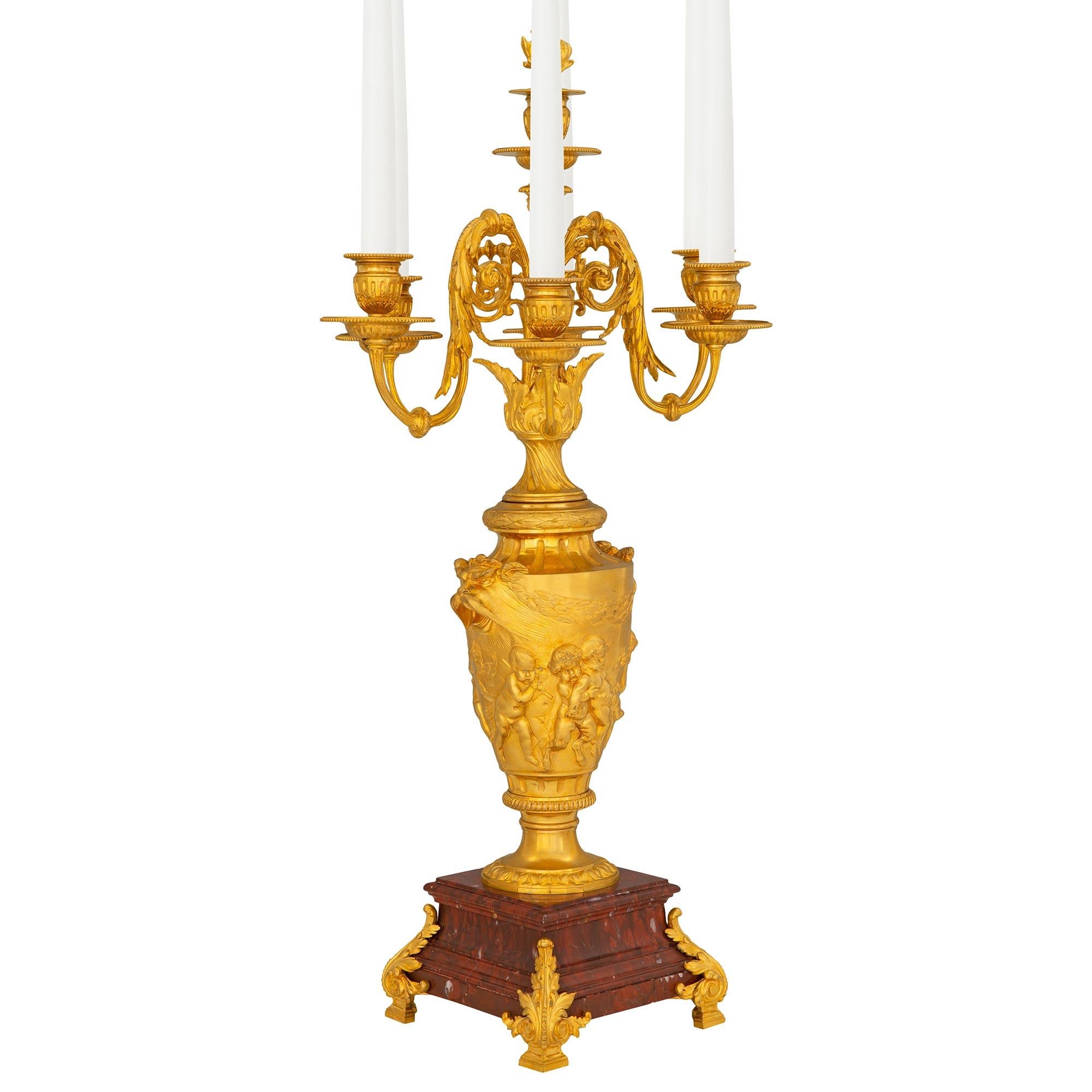 An exquisite pair of French 19th century Louis XVI st. Belle Époque period ormolu and Rouge Griotte marble candelabras, attributed to F. Barbedienne. Each seven arm candelabra is raised by elegant ormolu supports with Fine block feet and richly