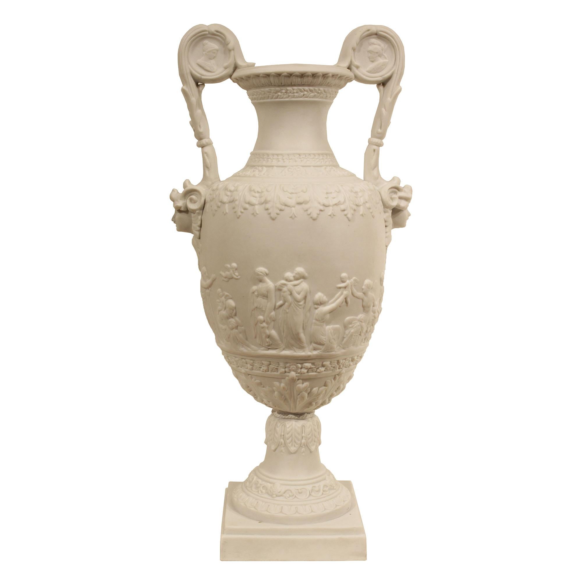A pair of 19th century Louis XVI st. Biscuit de Sèvres porcelain urns. Each urn is raised on a mottled square base below the socle decorated with a rai de coeur design below a scrolling garland and acanthus leaves. The urn above displays maidens