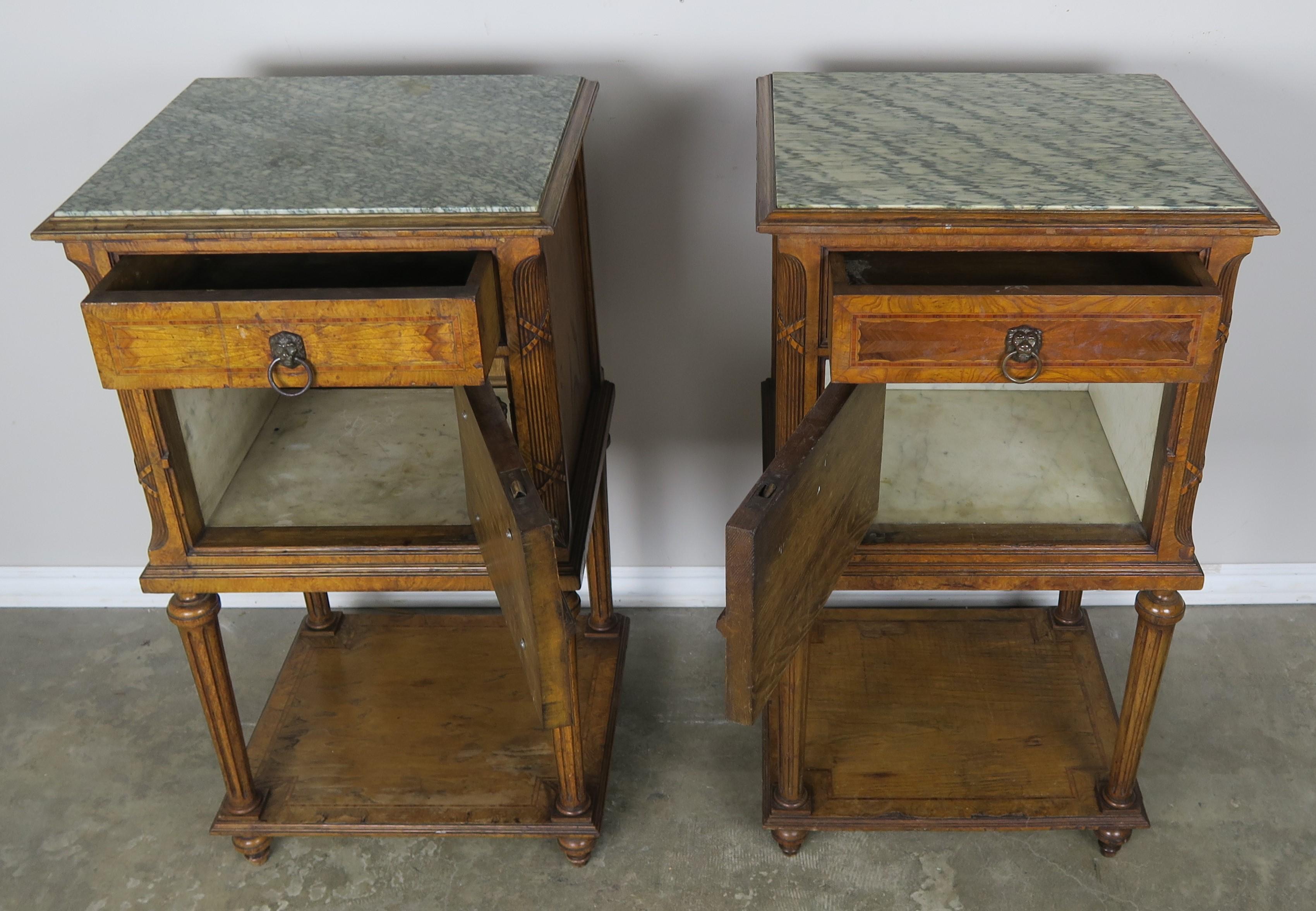 Pair of 19th century French walnut marquetry Louis XVI style night stands with green and white marble inset tops. The tables are beautifully inlaid and still have the original lion head hardward. The tables stand on four straight fluted legs and