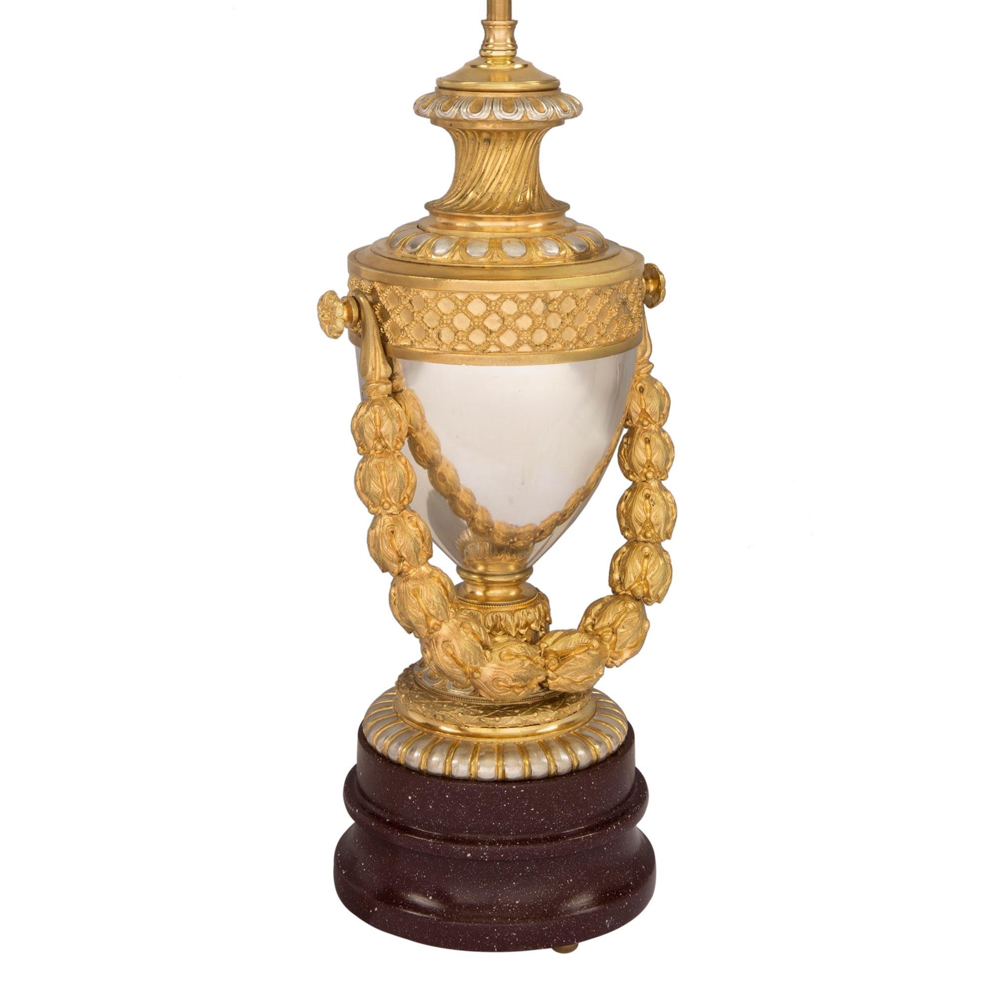 Una bellissima e unica coppia di lampade francesi del XIX secolo in stile Luigi XVI in ormolu, bronzo argentato e finto porfido dipinto. Ogni lampada è sollevata da una base circolare screziata con un meraviglioso disegno in finto porfido dipinto. I