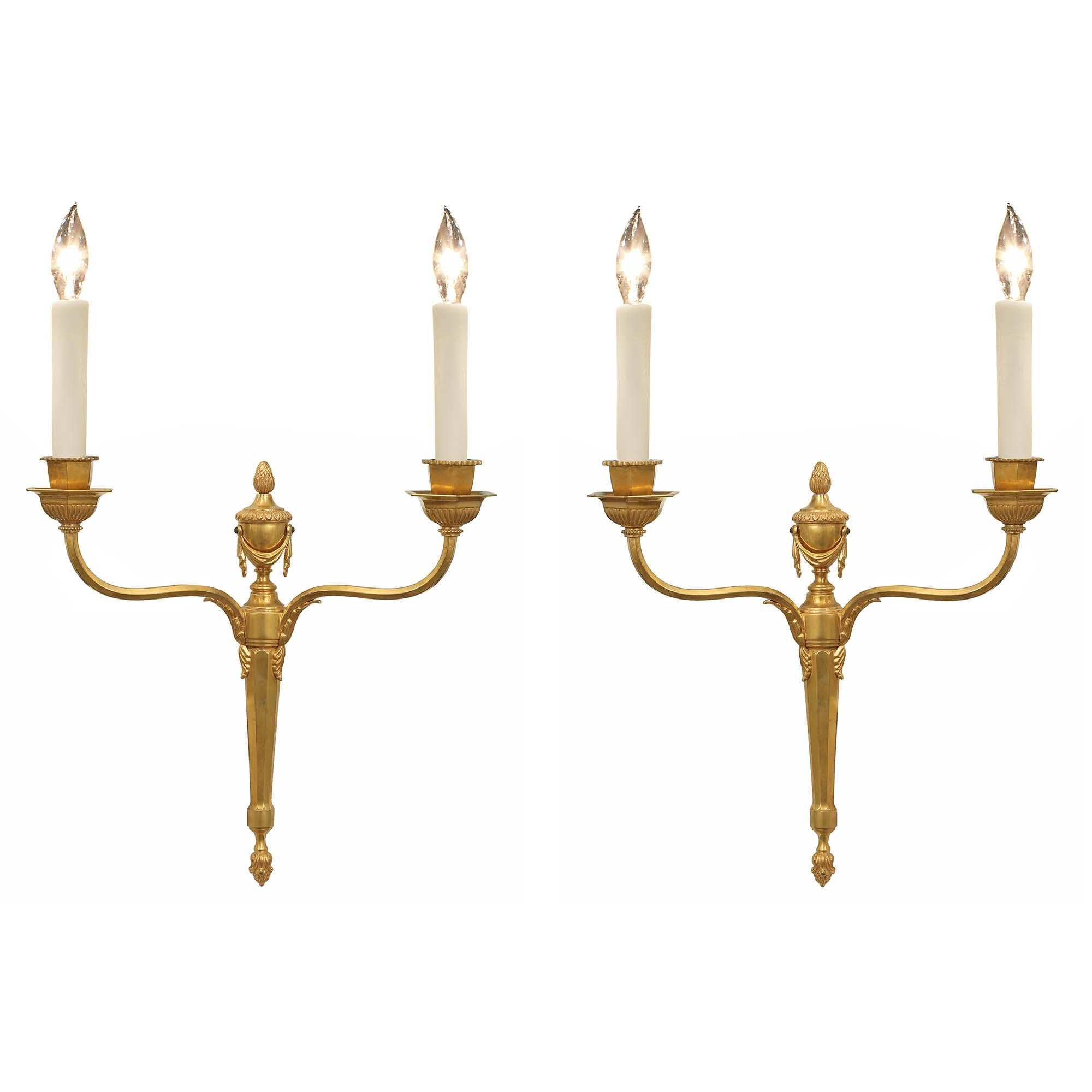 An attractive pair of French 19th century Louis XVI st. two arm ormolu sconces. The top of backplate has an urn with swaging drapes below are the two 'S' scrolled arms which have acanthus leaf mounts. The bottom of the backplate is a tapered fluted