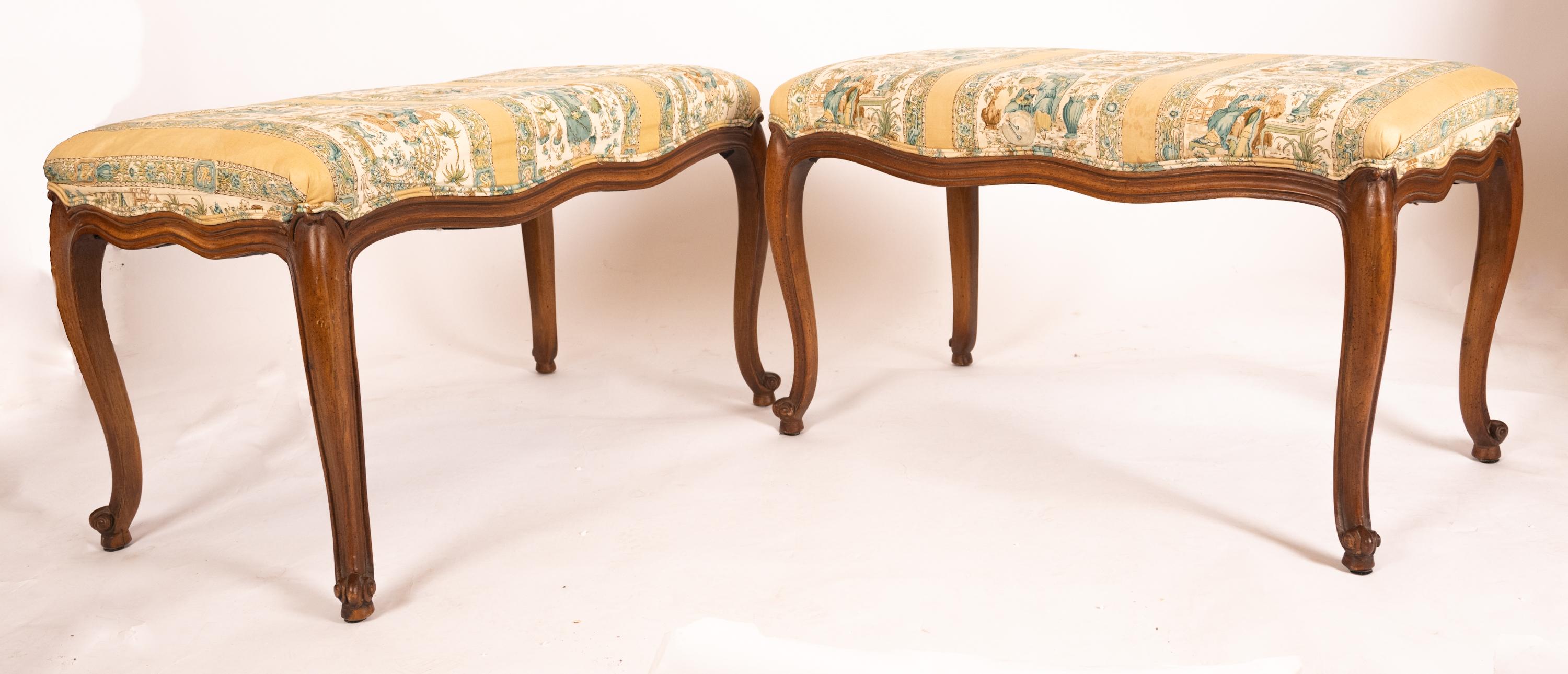 Coppia di panche francesi in stile Luigi XV con gambe cabriolet e struttura in legno di frutta intagliato a mano. Il legno di frutta ha una finitura noce media. Così come la tappezzeria in tessuto di cotone stampato. Circa 1950.