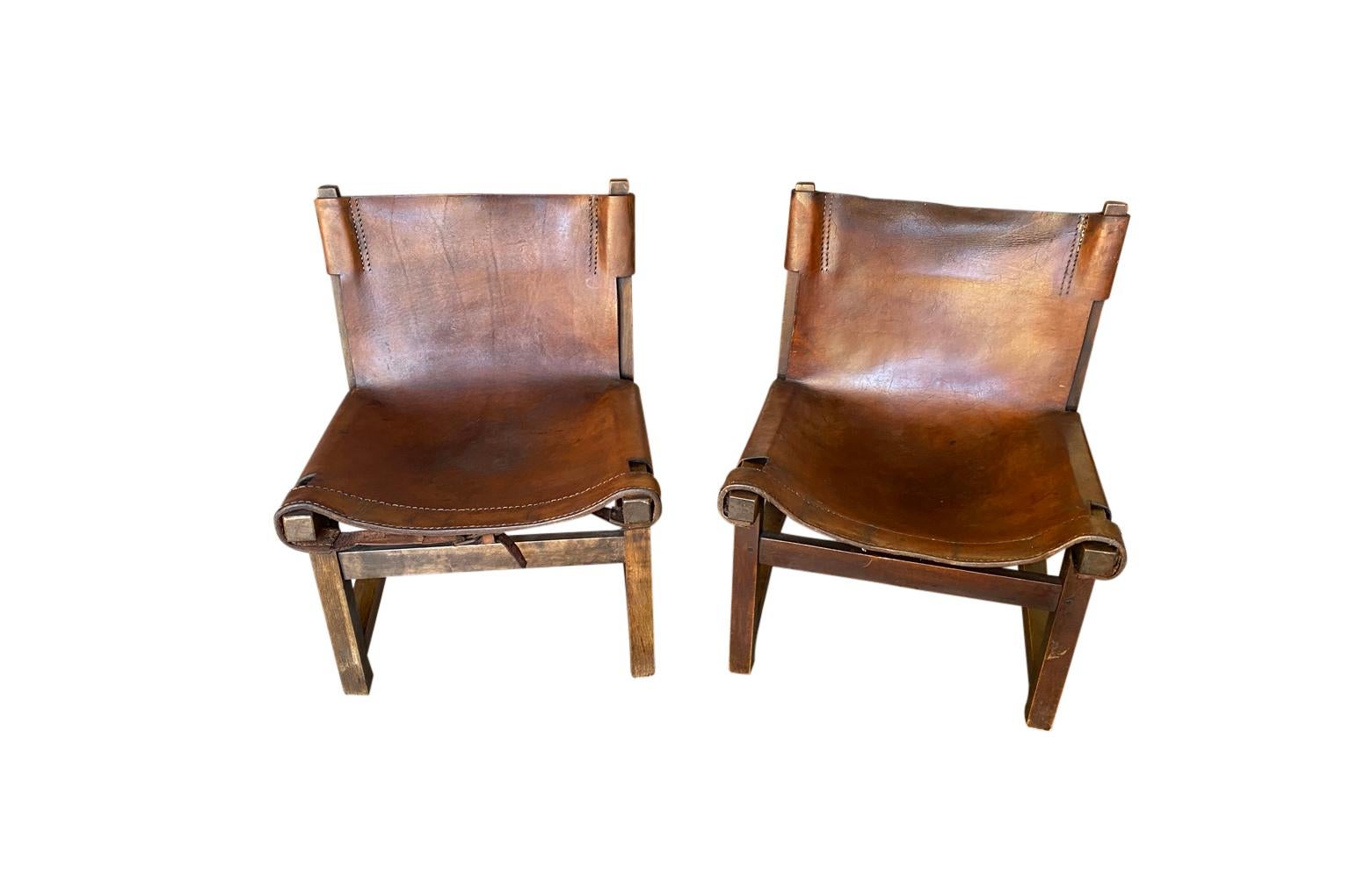 A very charming pair of 19th century low chairs soundly constructed from leather and wood. Very sturdy and comfortable. Great patina. The seat height is 12 1/4