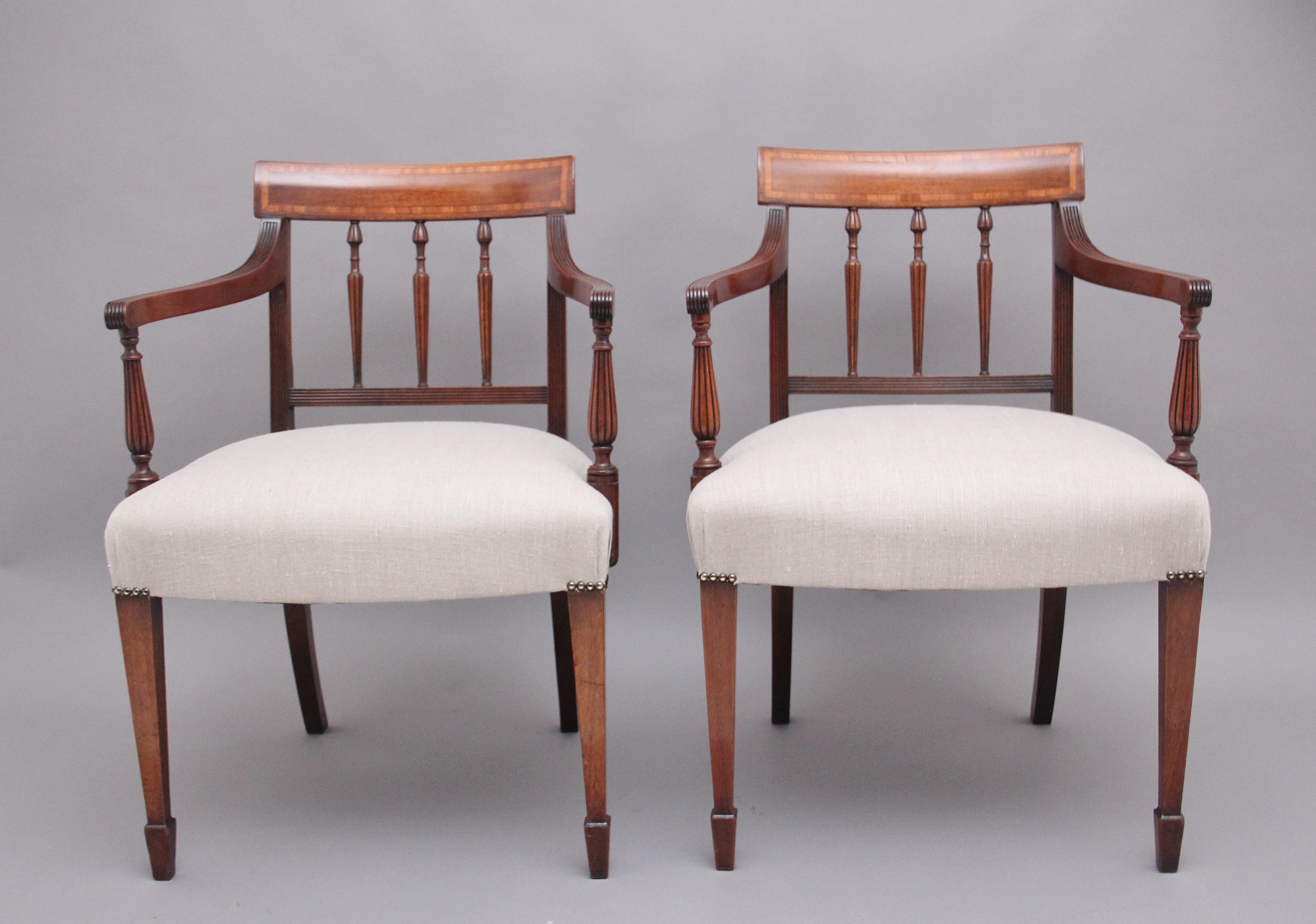A pair of 19th century mahogany armchairs, having a shaped and inlaid top rail above three finely turned spindles, having wonderfully shaped and reeded arms with decorative turned supports, recently been reupholstered in a grey stuffover seat,