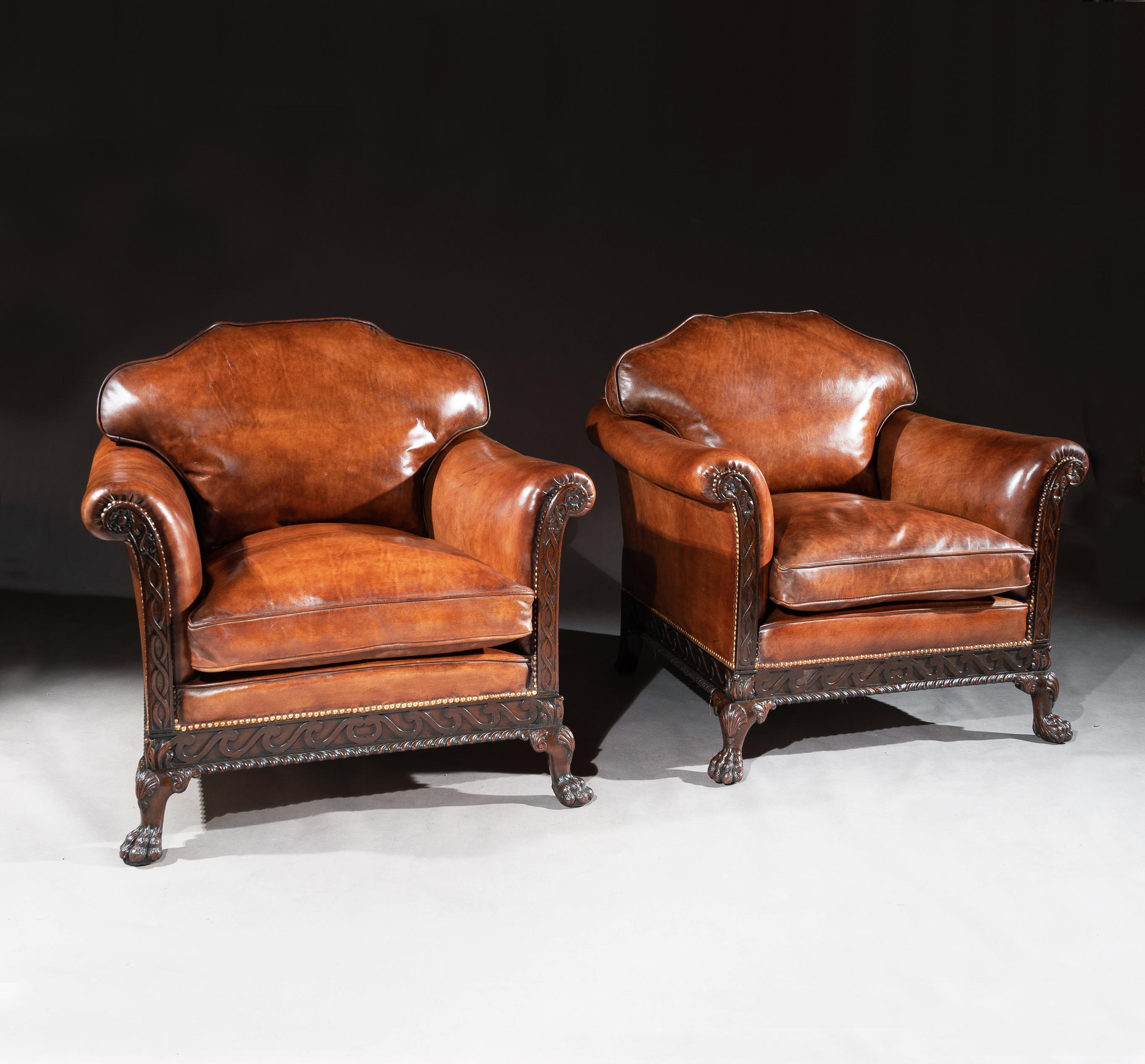 A fine pair of late 19th century George II style carved mahogany country house leather upholstered armchairs of generous proportions.

English, circa 1880


A handsome pair of antique leather armchairs having the desirable feathered cushioned