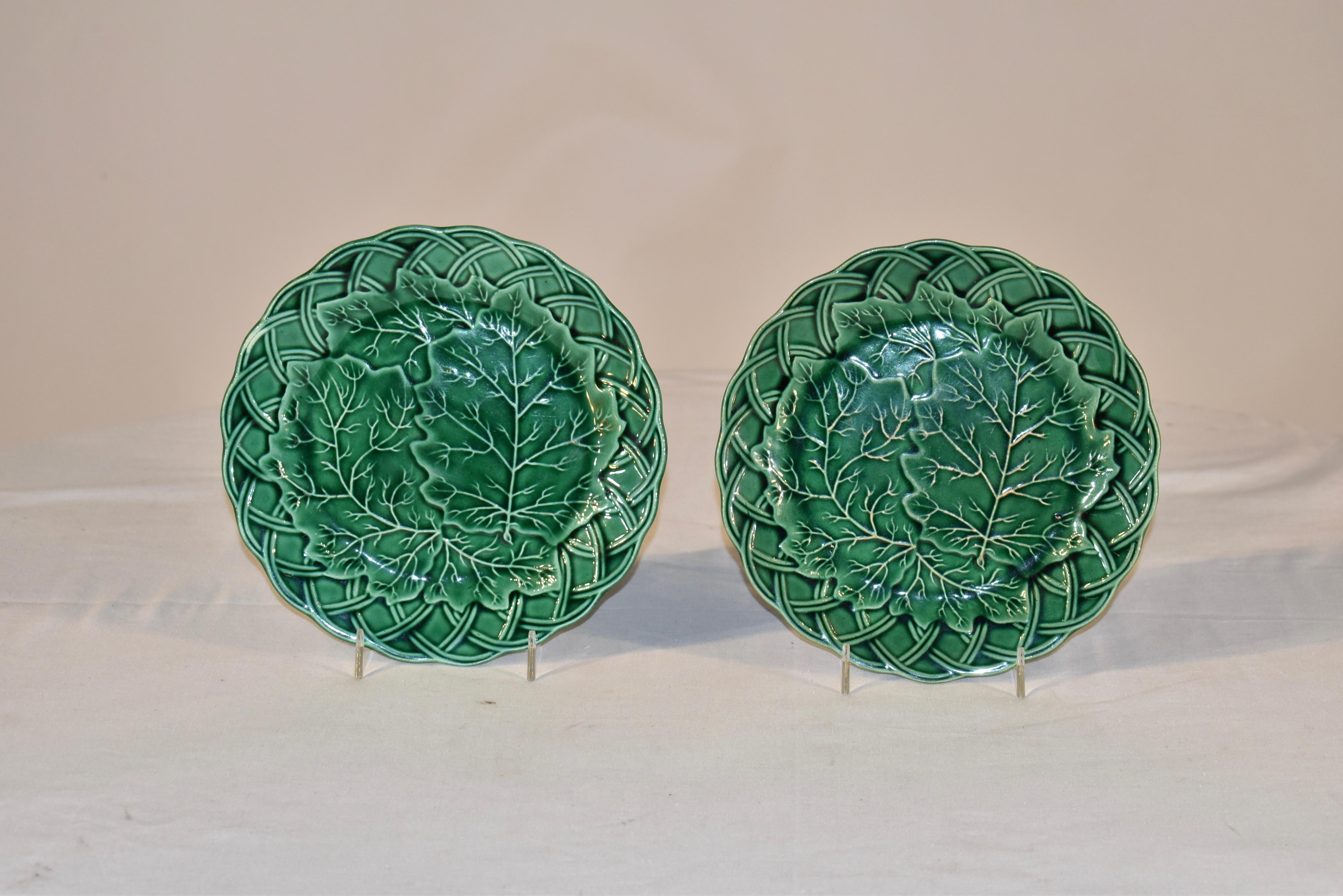 Pair of 19th century green glazed Majolica plates from England. They have a nicely relieved pressing of a basket weave border, surrounding a central large leaf pattern. They are glazed in a rich shade of green and would be a lovely addition to any