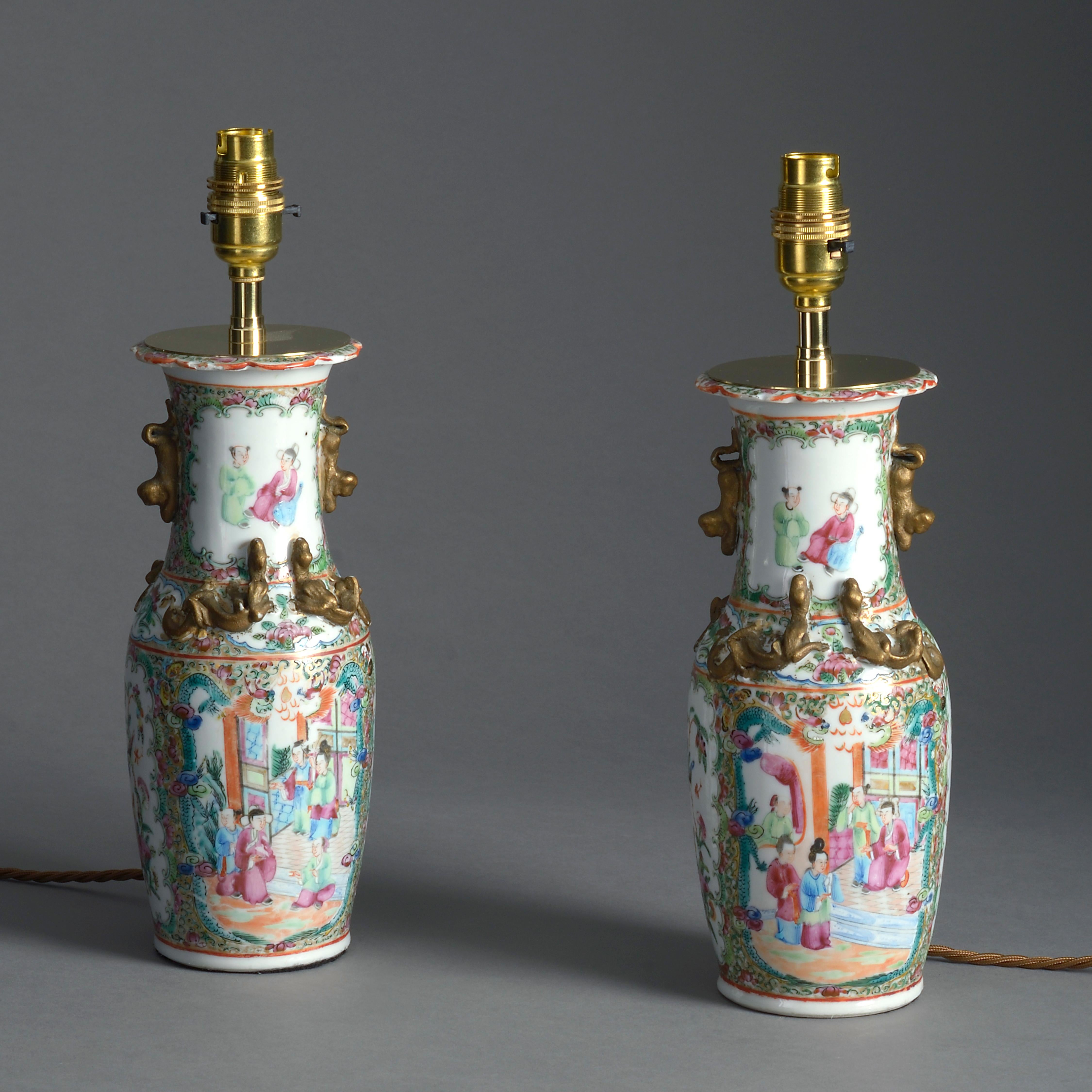 A pair of small scale famille rose porcelain mandarin vases, decorated throughout with figurative cartouches, birds, insects and flowers, with gilded dragons upon the shoulders in the traditional manner. Now mounted as table lamps.

Dimensions