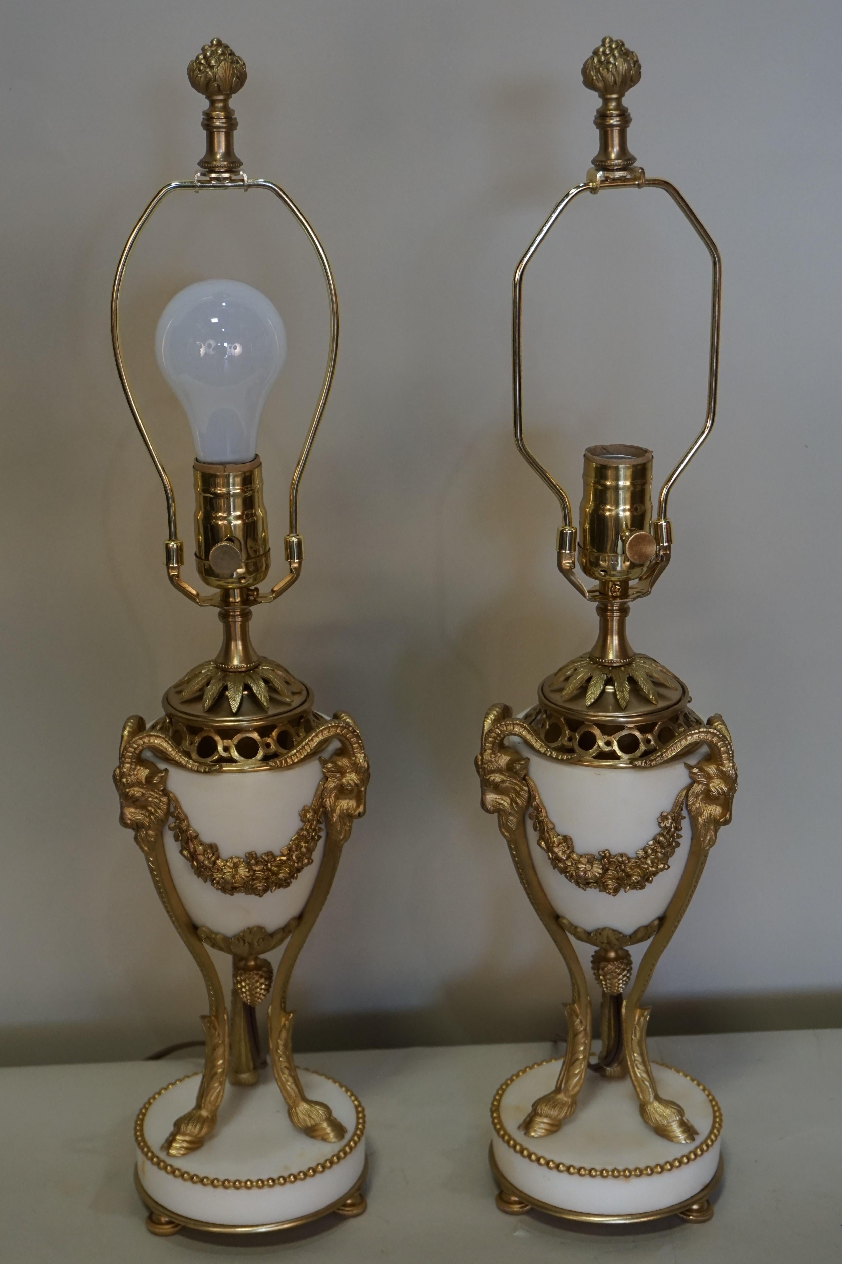 Electrified pair of 19th century bronze and marble urns and fitted with silk lampshades.