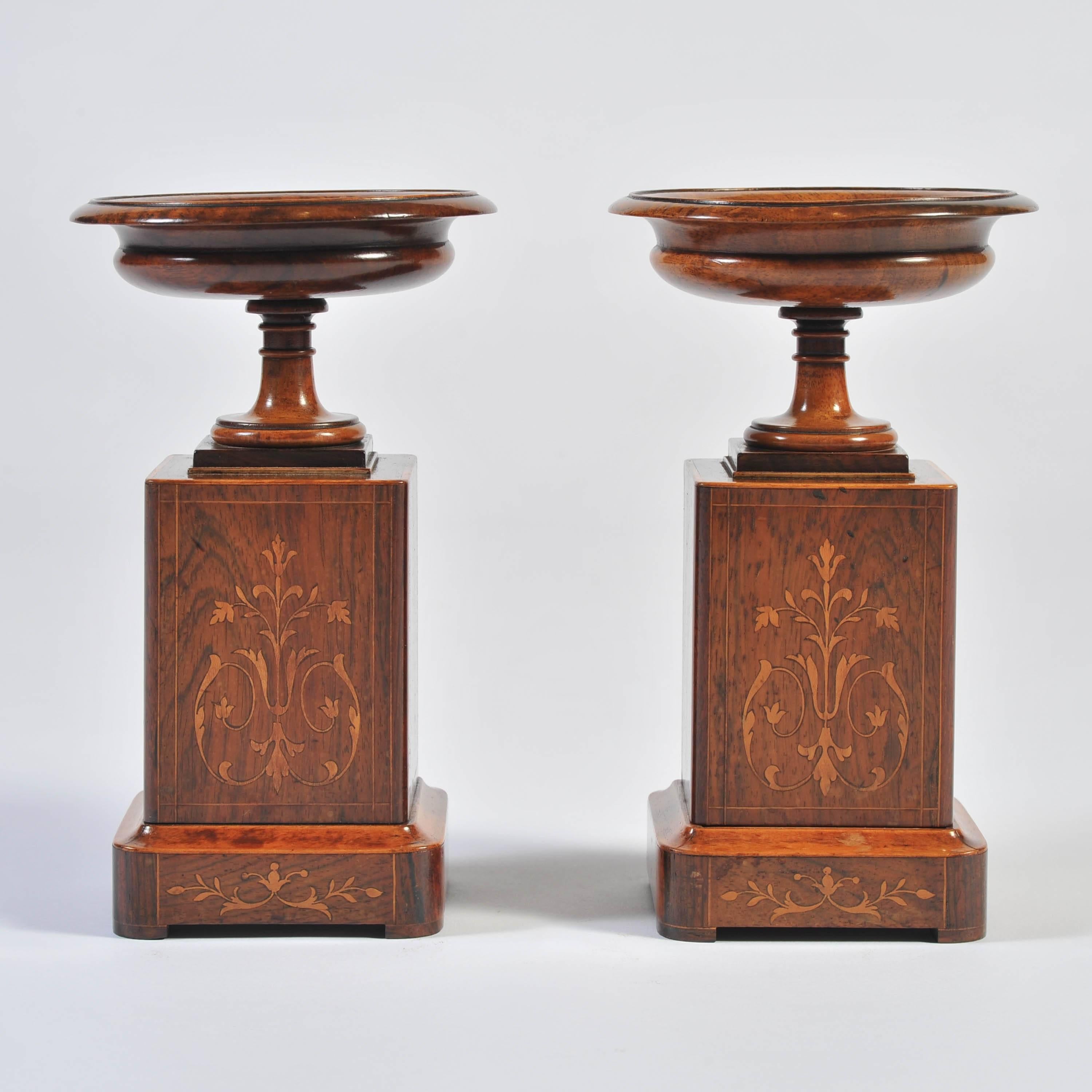 The kylix shape turned dishes of walnut with central ebony and boxwood inlaid paterae, on square block supports and plinths of rosewood with further fine boxwood marquetry.