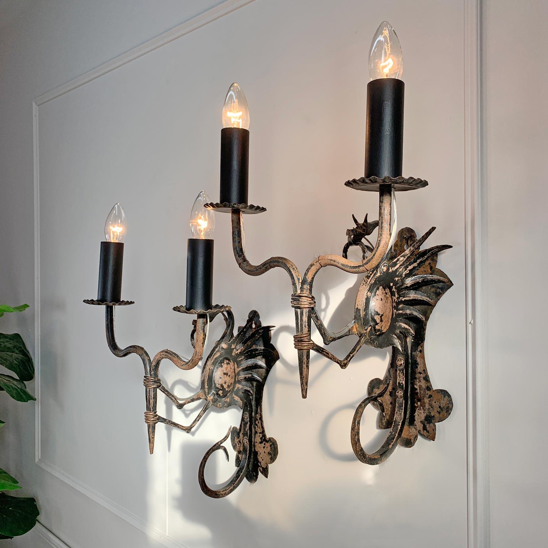 An incredible pair of late 19th century wrought iron wall lights/ torchiere's. This stunning pair of hand crafted Dragons are attributed to the Italian Master Ironworker Alessandro Mazzucotelli. These would have originally been holding candles but