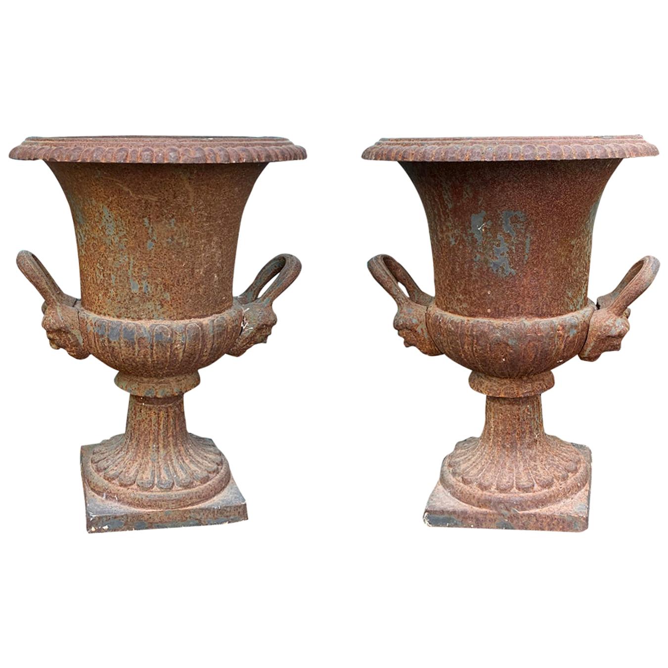 Pair of 19th Century Neoclassical Iron Urns with Handles and Face Detail For Sale