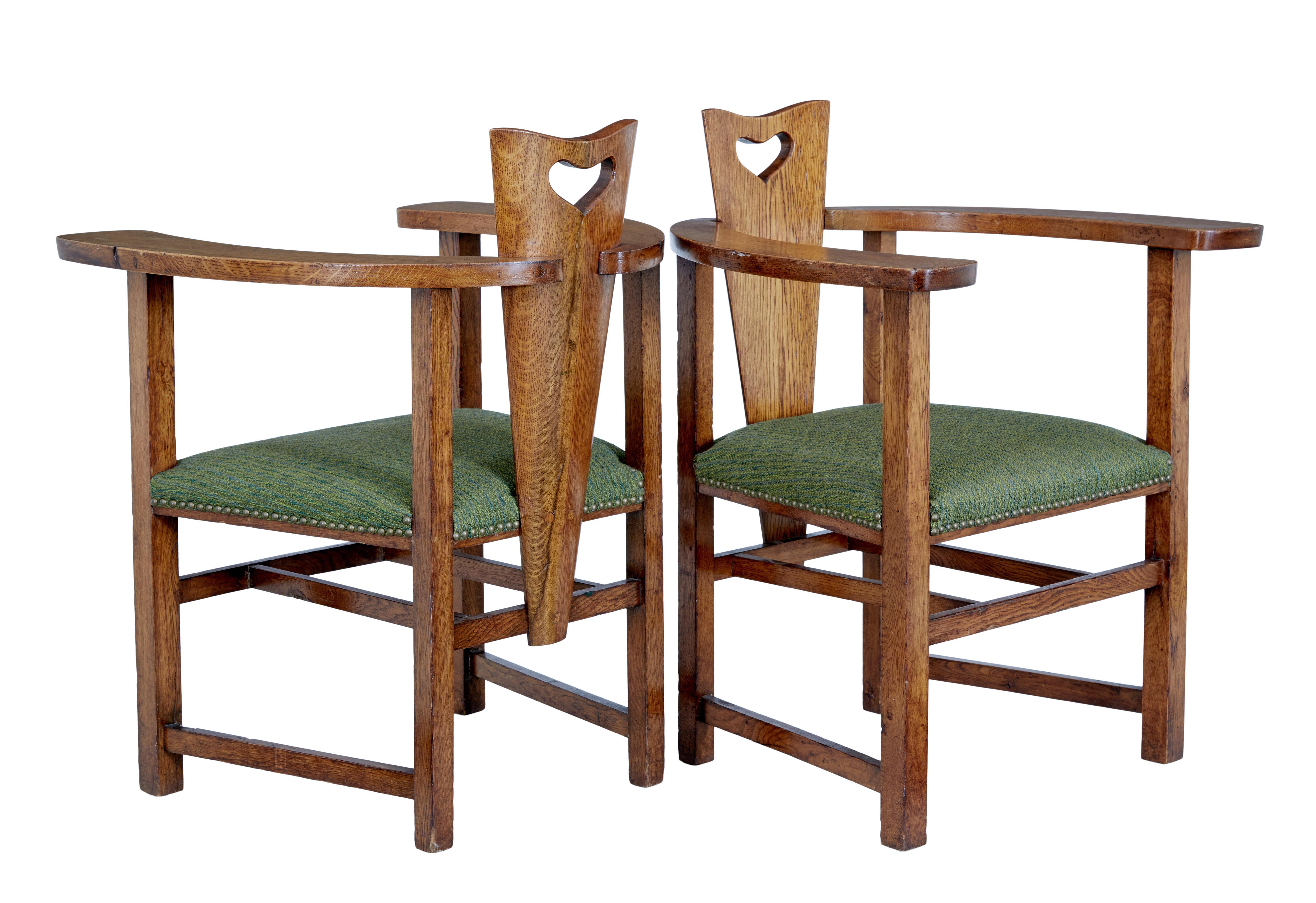 Pair of 19th century oak Arts & Crafts armchairs circa 1890.

Unusual shaped pair of english arts and crafts armchairs. Shaped backs with heart shaped handle, these link to the swooping wide arm. Standing on straight legs united by stretchers.