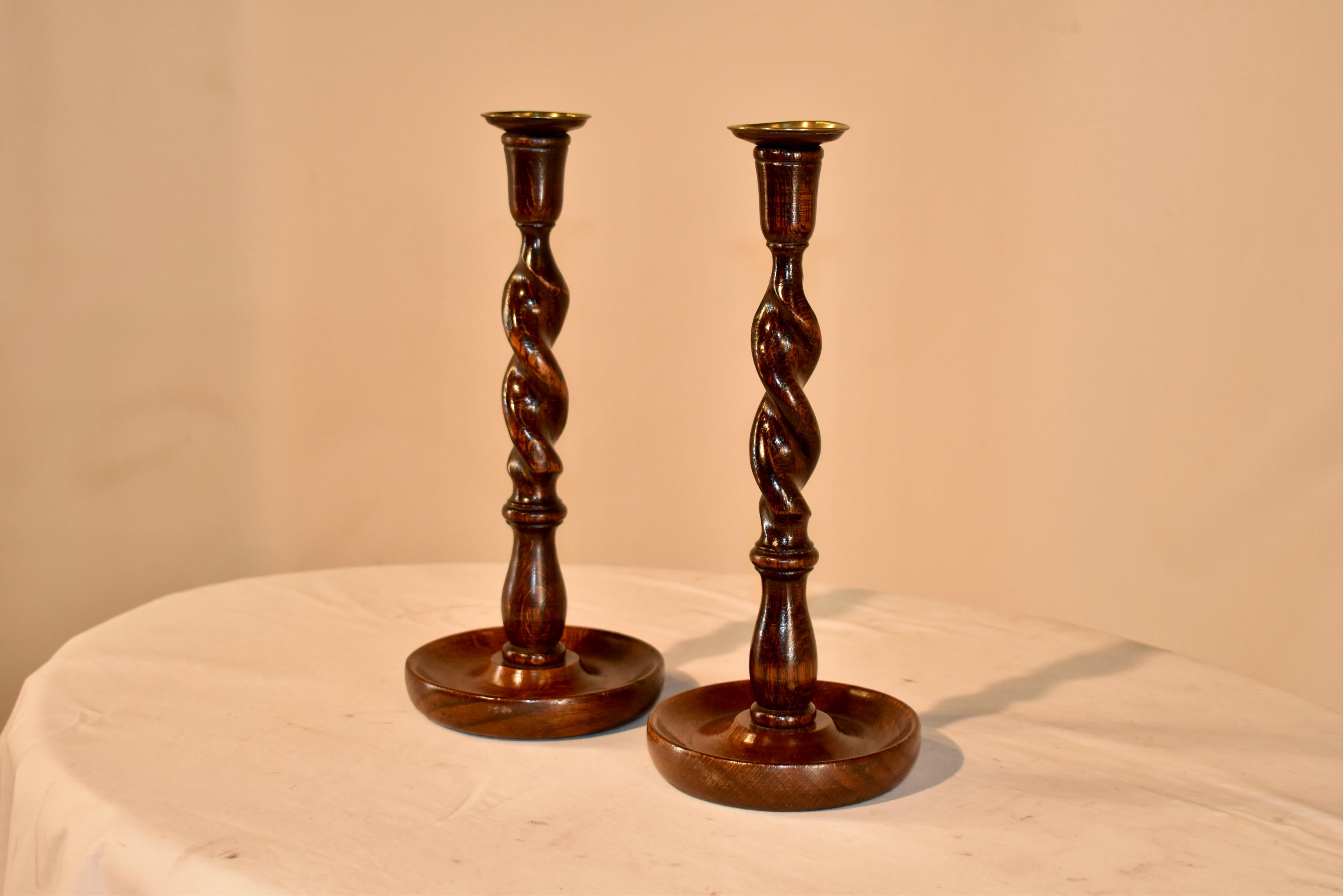 Pair of 19th century oak candlesticks from England with hand turned brass candle cups, supported on hand turned candle cups and barley twist stems, sitting on a hand turned dish shaped base.