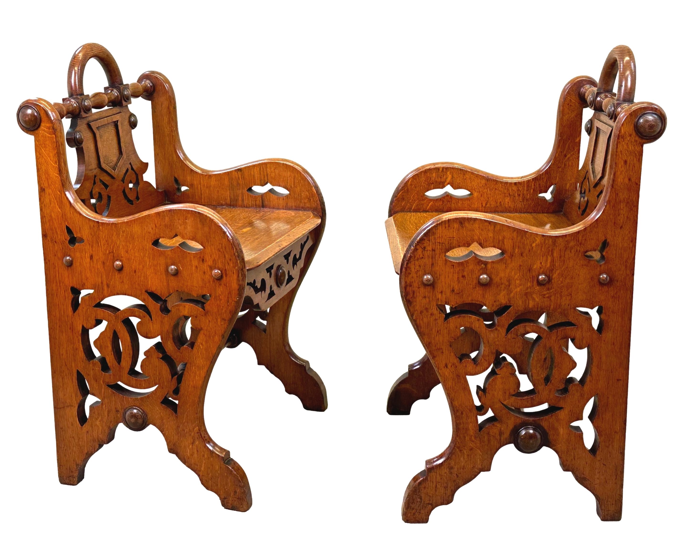 Paire très attrayante de sièges de salle ou de fenêtre en chêne de la fin du XIXe siècle, avec des brancards tournés sur le dessus, une poignée de transport et une élégante décoration en forme sur les dossiers, sur des sièges solides flanqués de