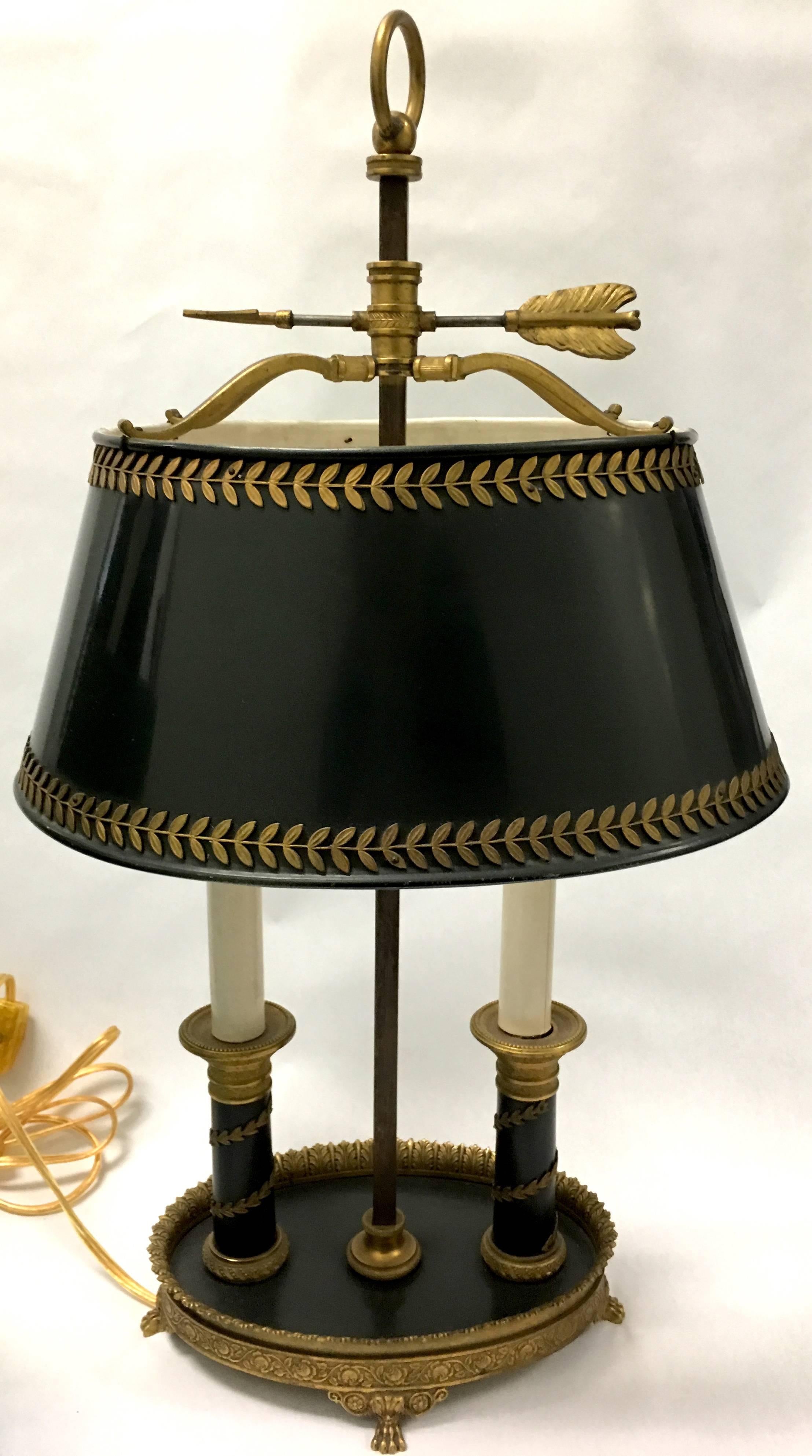 Pair of late 19th century bouillotte table lamps. Lamps feature original elements and original black tole lampshades with gilt brass leaf applied detailing. Newly rewired with side switches. Each lamp take two chandelier size bulbs.