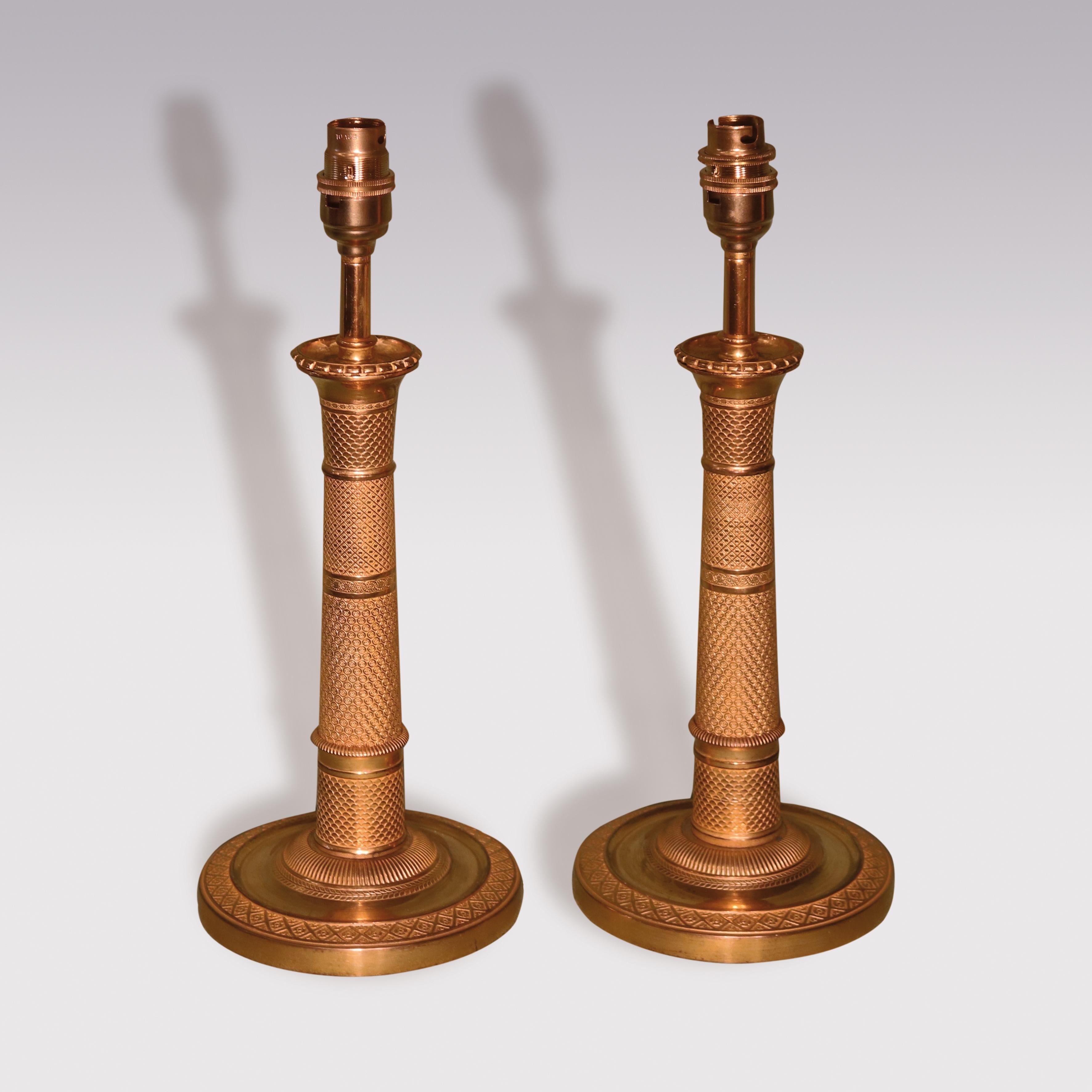 Pair of early 19th century ormolu candlesticks having unusual engine-turned “column” stems supported on circular bases. (Now converted to lamps)

Measures: Height of candlesticks 10