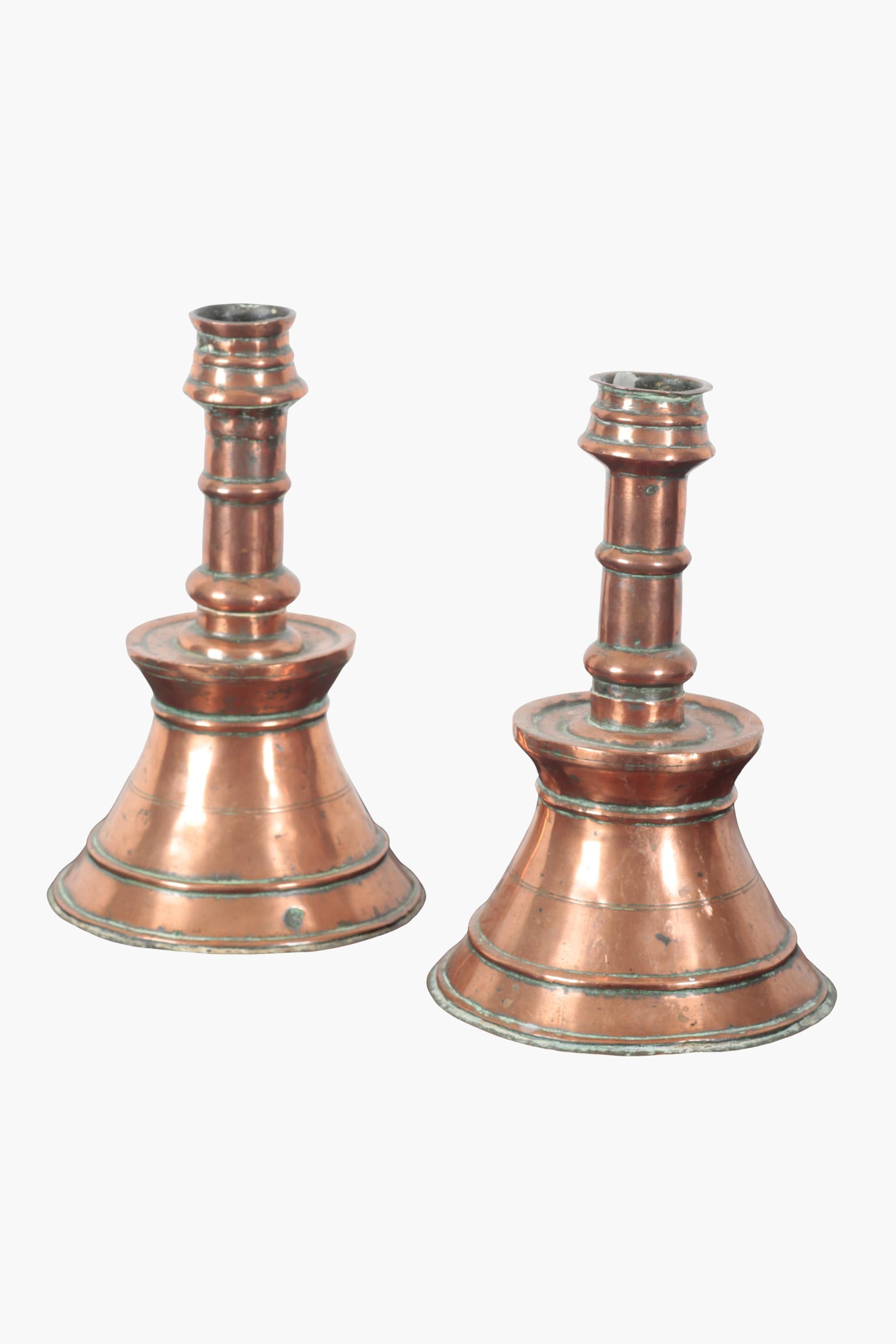 Two copper candlesticks of typical ottoman form with turned stems on a stepped and tapered base. Each base rises to a flared bobèche (a drip tray to collect melted wax).

Made in the 19th century, based on 15th and 16th century designs, when this