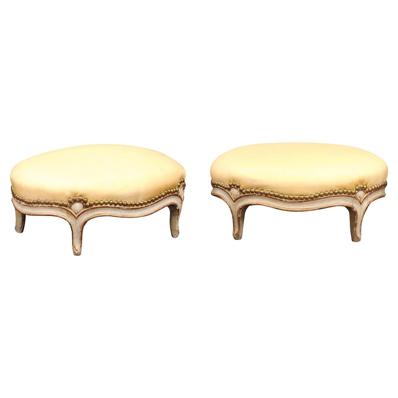 Paire de tabourets ovales de style Louis XVI du 19ème siècle peints et dorés à la feuille