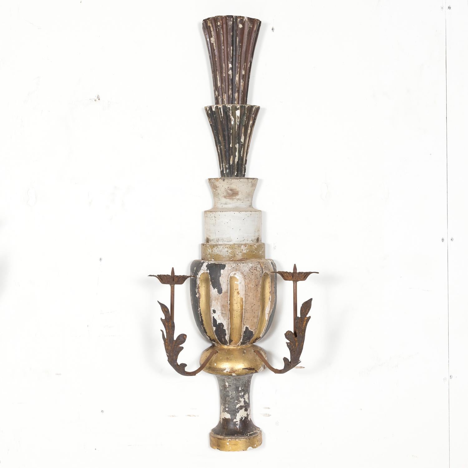 A large pair of 19th century hand carved wooden Italian candle sconces handcrafted in Florence, circa 1890s, having a painted and parcel gilt finish with two large iron arms featuring acanthus leaf motifs. Sconces vary slightly. 
Dimensions:
H -