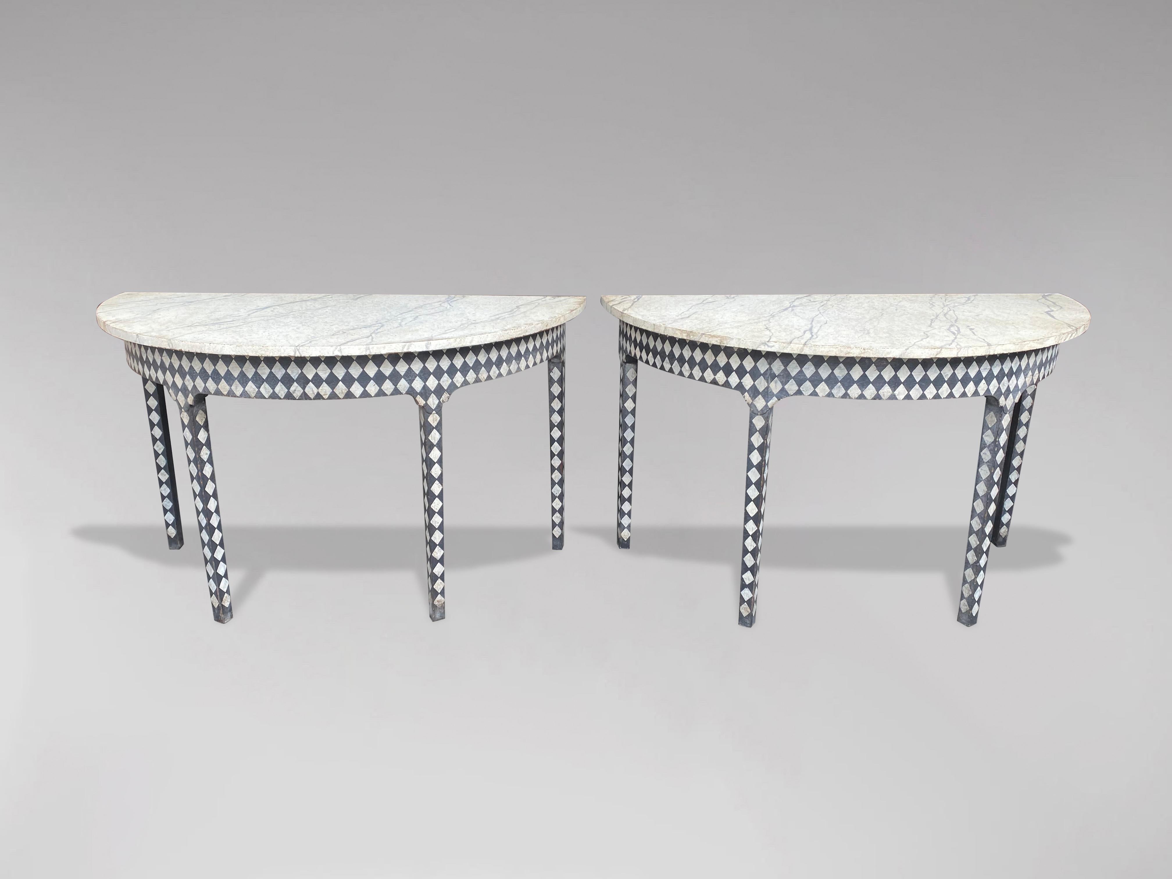 A charming pair of early 19th century demi-lune console tables. English in origin and dating to the late Georgian period. Now painted in a geometric design with faux marble tops. Each table stands on 4 tapered legs. Fabulous used either as a pair or