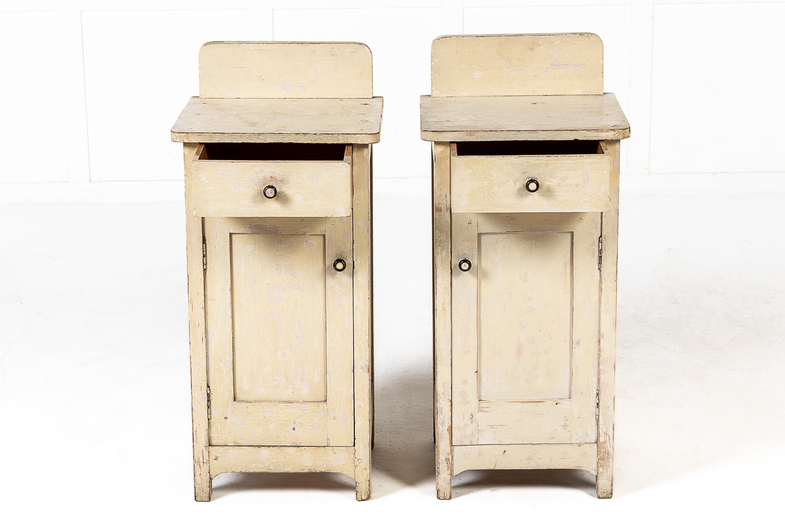 A pair of 19th century painted pot cabinets with single drawer, and panelled doors open to reveal shelves within. The tops have a back panel.
