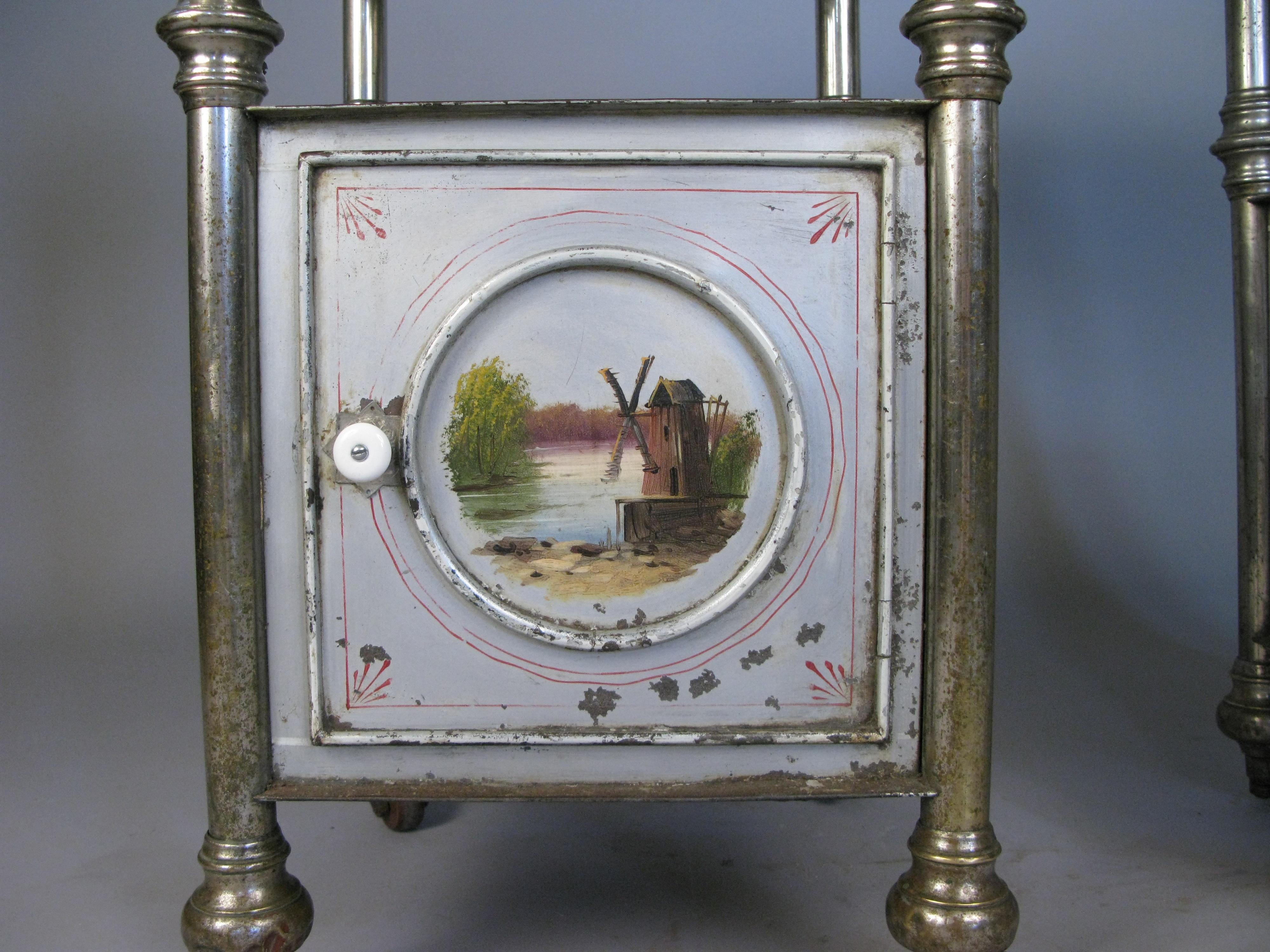 a pair of robust antique 19th century eastern European steel nightstands with hand painted pictorial scenes on the fronts, on their original casters with new stone tops.