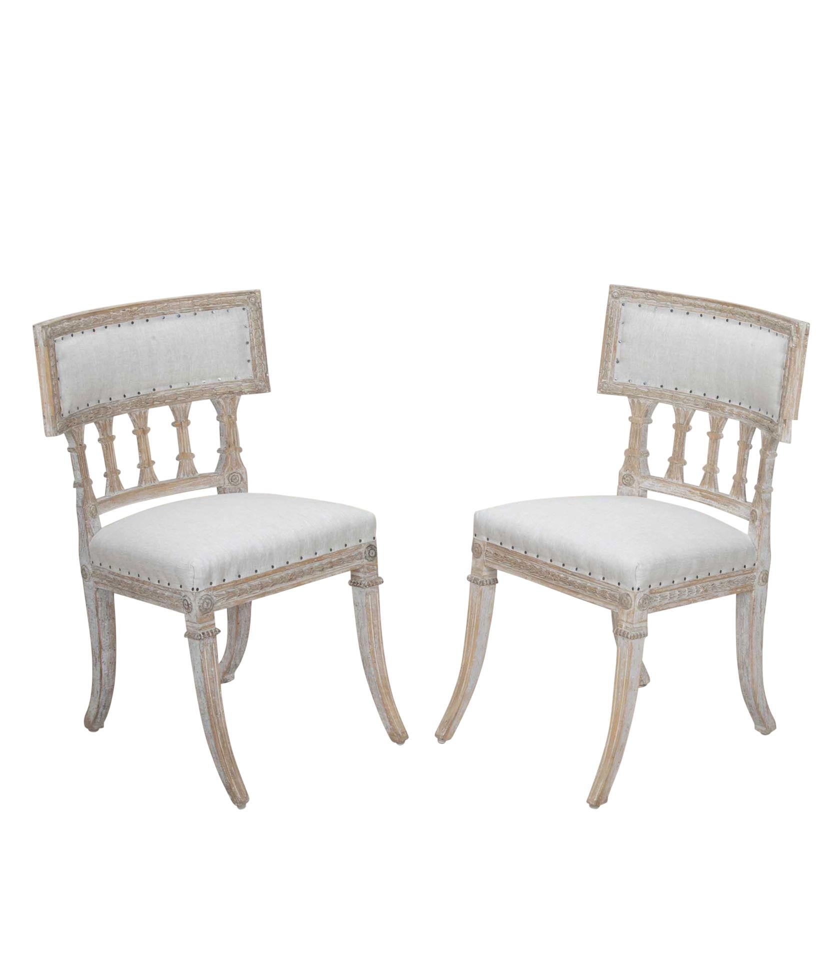 Coppia di sedie klismos gustaviane dell'inizio del XIX secolo.
Con dettagli intagliati intorno alle sedie e lungo le gambe. Riverniciato in grigio tenue e rivestito in lino.
Circa 1820.