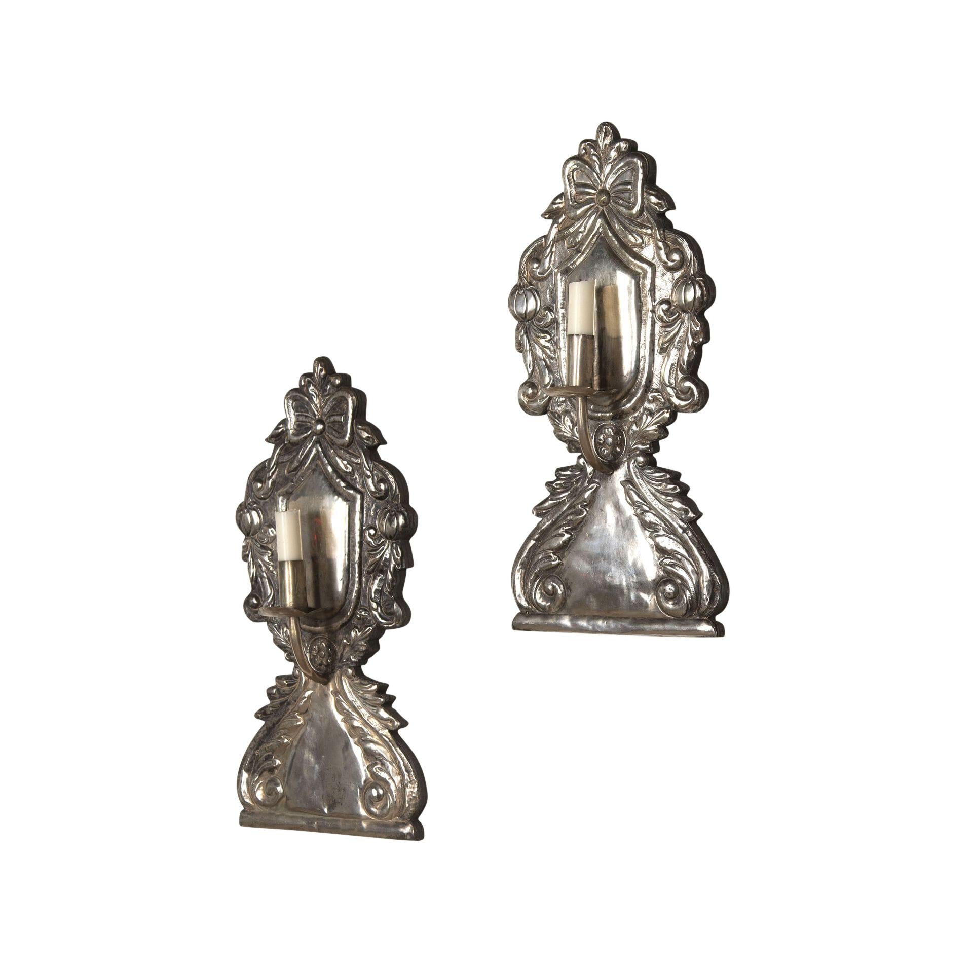Pair of 19th century pressed metal wall lights with decorative fruit and bow design.