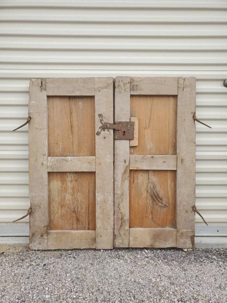 A rustic pair of solid mesquite and pine antique windows from Mexico. Handcrafted in the 19th century, retaining most of the hand forged iron including hinges. Constructed using peg, mortise and tenon joinery,

This architectural salvage from