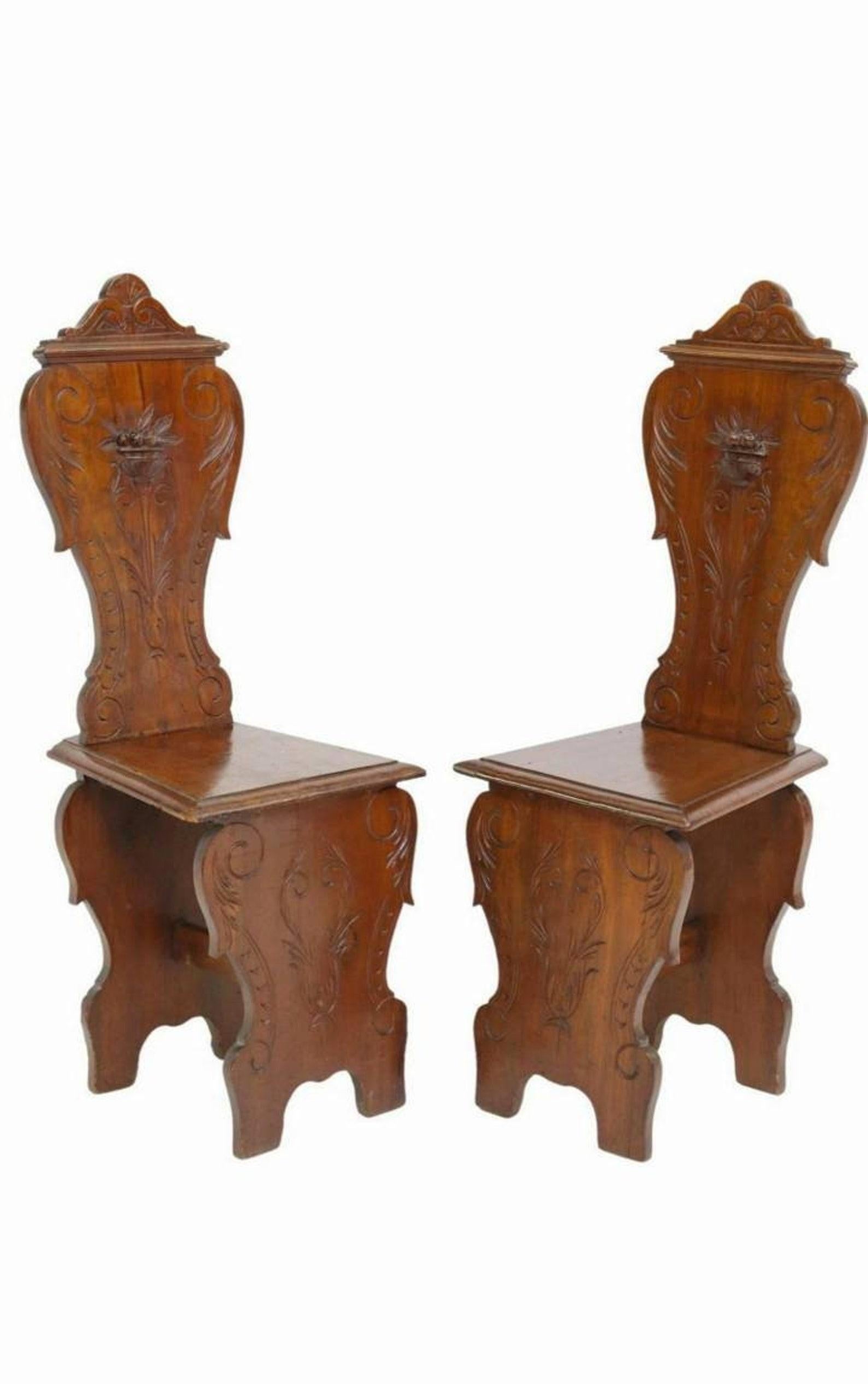 A pair of antique, circa 1830, Italian Renaissance style hand carved walnut sgabello hall chairs.

Hand-crafted in Provincial Italy, most likely Tuscan region of central Italy, in the first half of the 19th century.

This form of decorative