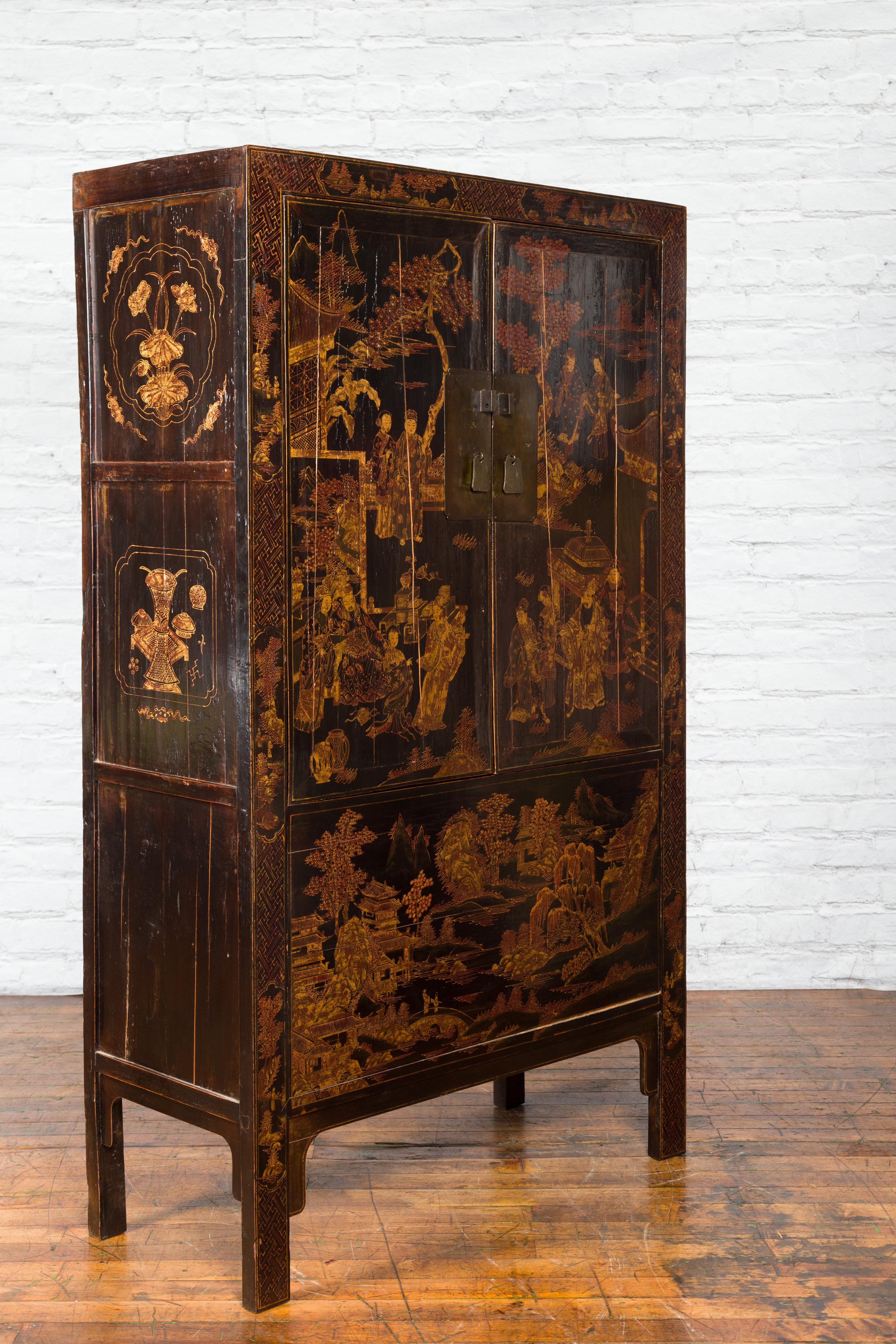 A pair of Chinese Qing Dynasty period black lacquered cabinets from the 19th century, with gilt Chinoiserie décor and hidden drawers. Created in China during the Qing Dynasty era, each of this pair of cabinets features a black lacquered ground