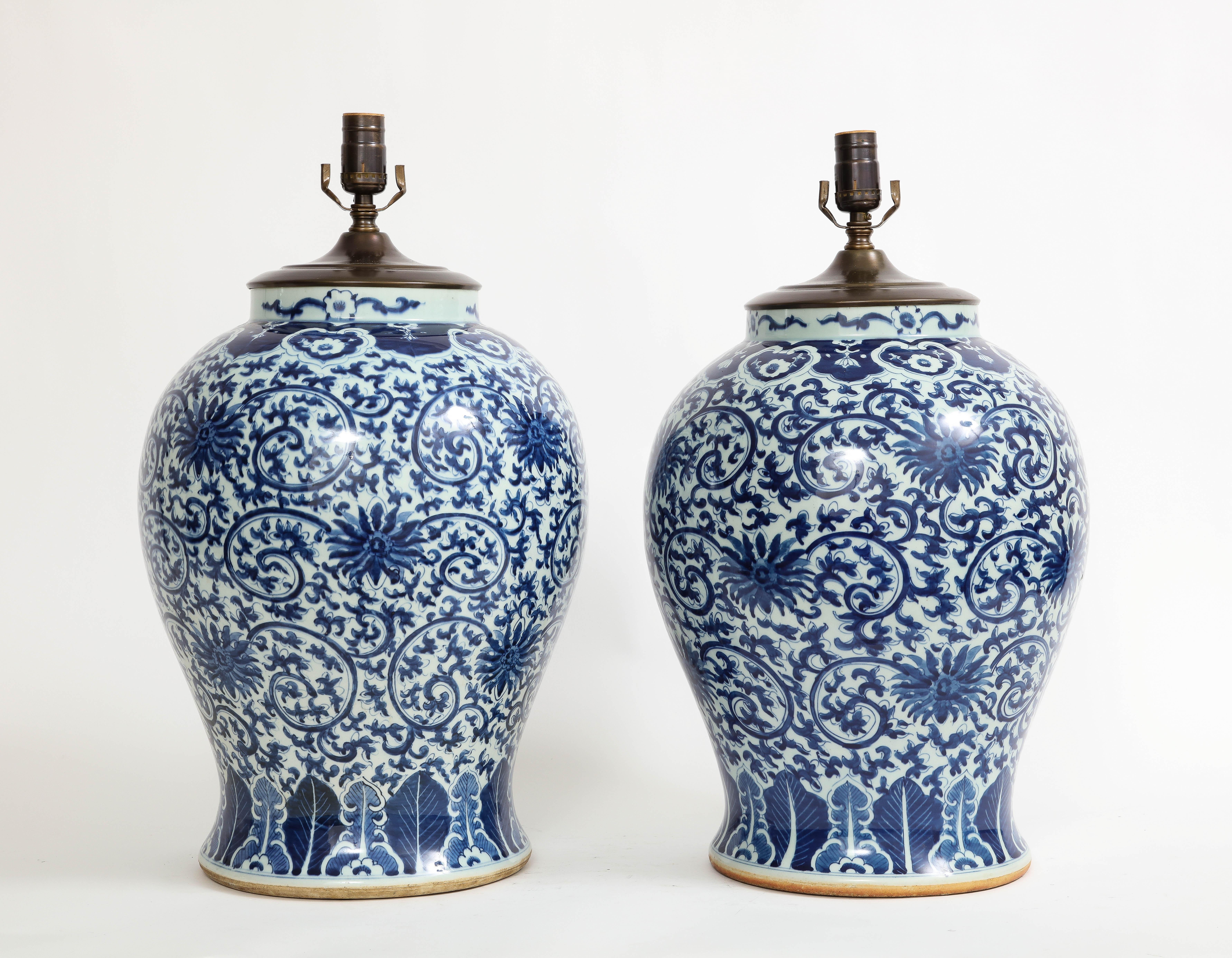 A magnificent and large pair of 19th century Qing Dynasty Chinese blue and white porcelain vases mounted as lamps. Each is beautifully hand painted with elaborate blue flowers and vines which run all around the bodies of the vases in the Safavid