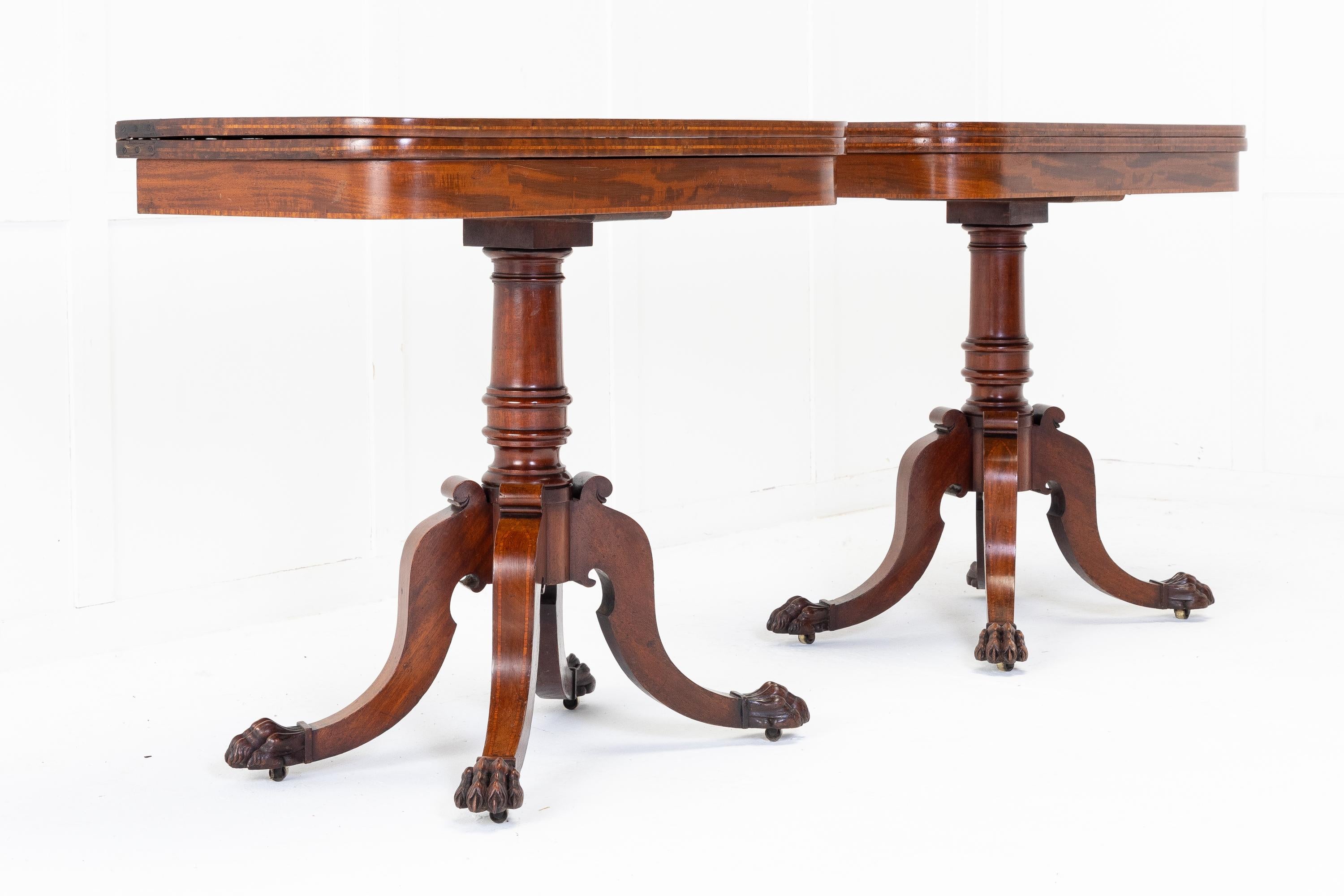 A very good pair of Regency card tables with fold-over D-shaped tops with satinwood crossbanding. The well figured mahogany tops, above a shallow frieze, open to reveal the old green baize. Supported by elegant turned columns and raised on