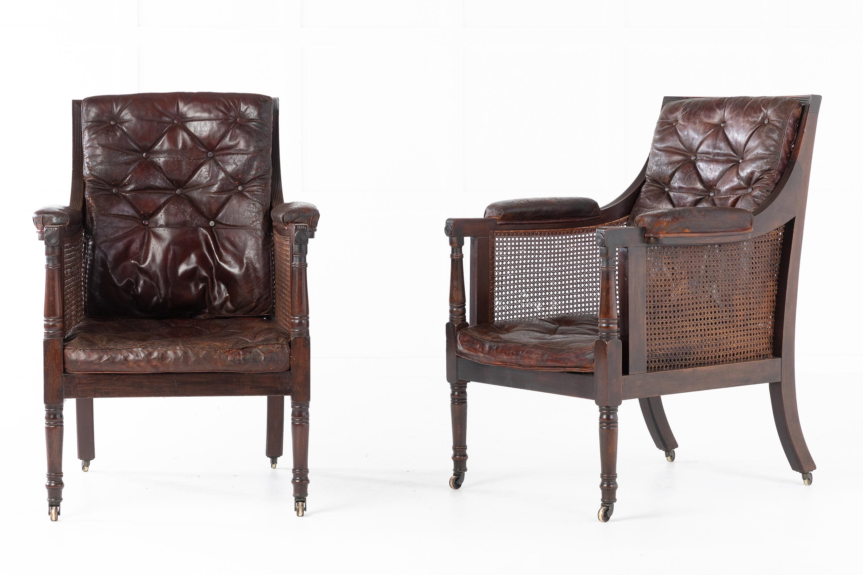 These fine, great sized and very comfortable pair of Regency mahogany library bergères, have backs and arms with reeded decoration and turned supports. They have caned seats and backs and are fitted with the original, beautifully worn buttoned hide
