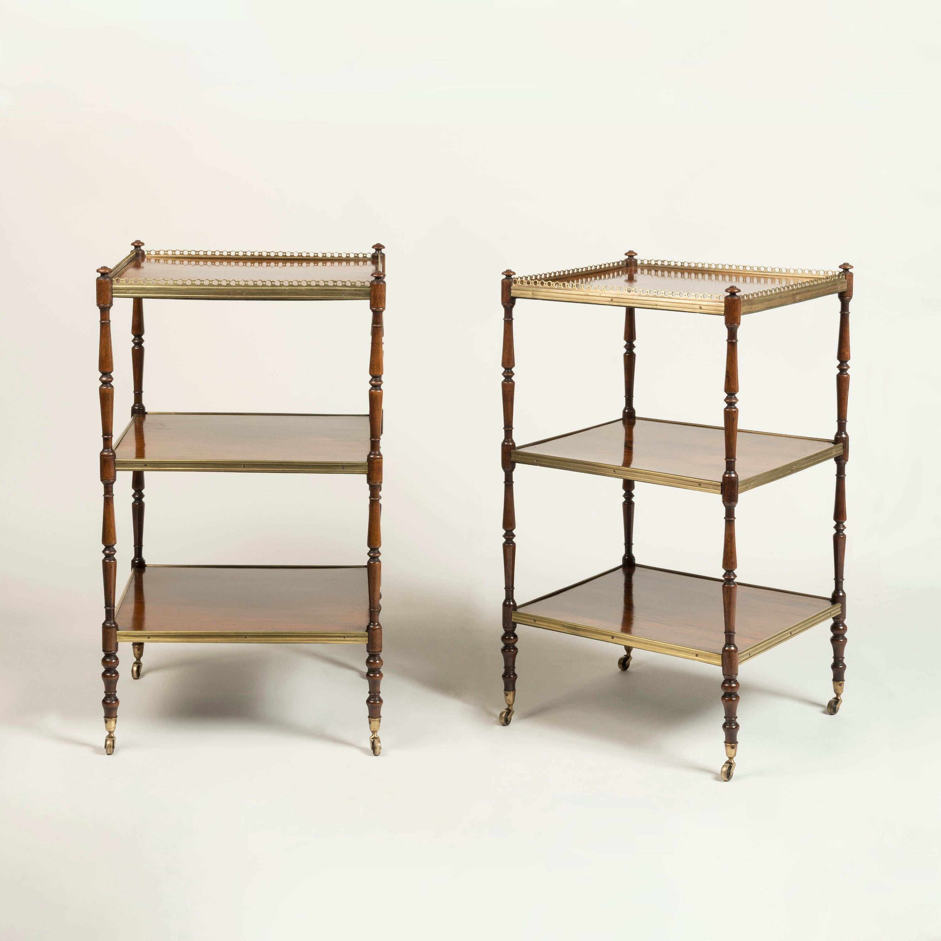 A Fine Pair of Regency Period Rosewood Étagères

Of elegant proportions, with carved tapering and ring-turned rosewood supports, standing on brass castors, each of the three shelves with a handsome grained rosewood; the top with a pierced brass
