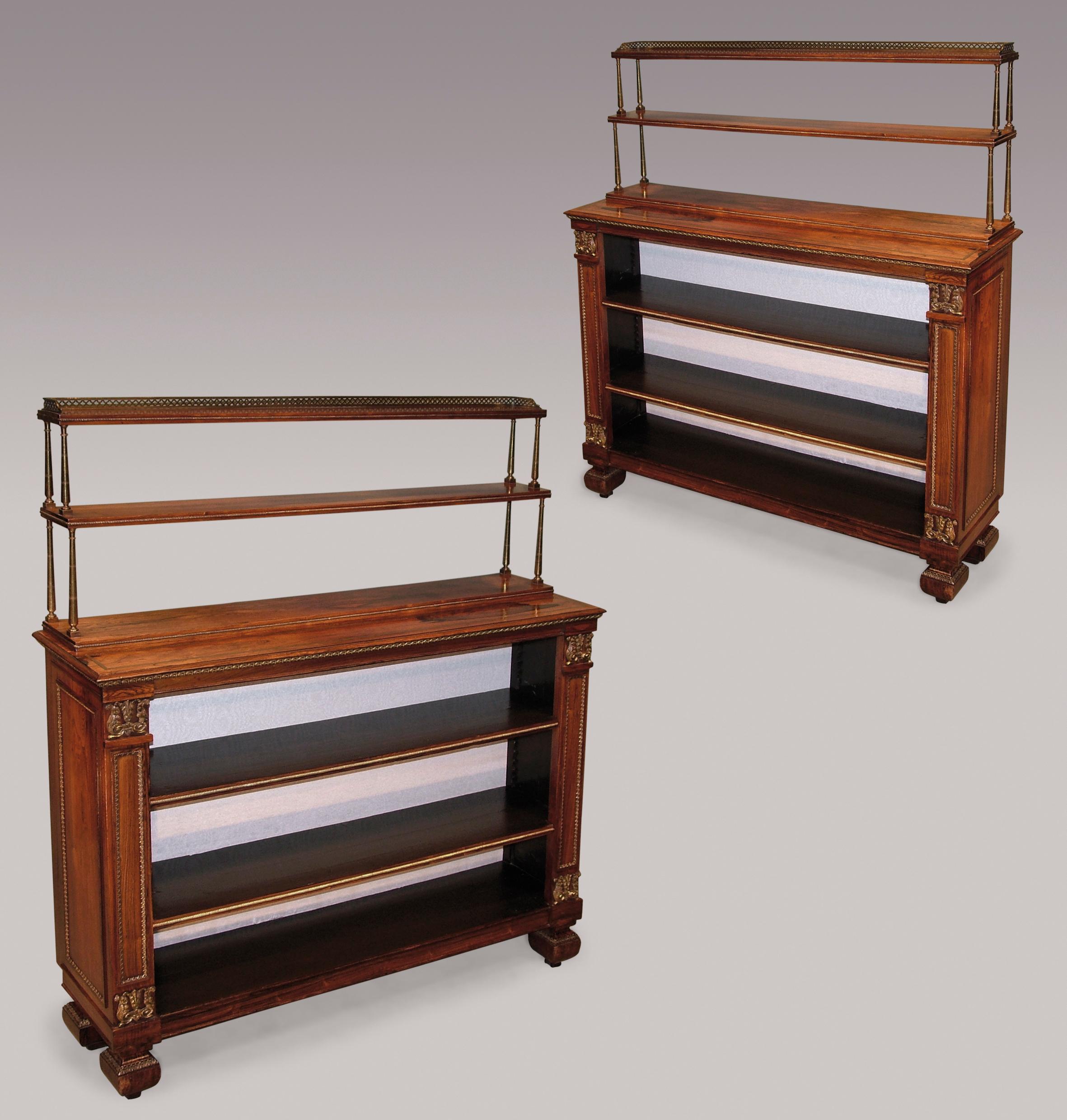 A fine quality pair of early 19th century Regency period rosewood open bookshelves, having gilt brass columned superstructures mounted with pierced galleries and inset beading, above brass inlaid moulded edged tops, the shelves flanked by paneled