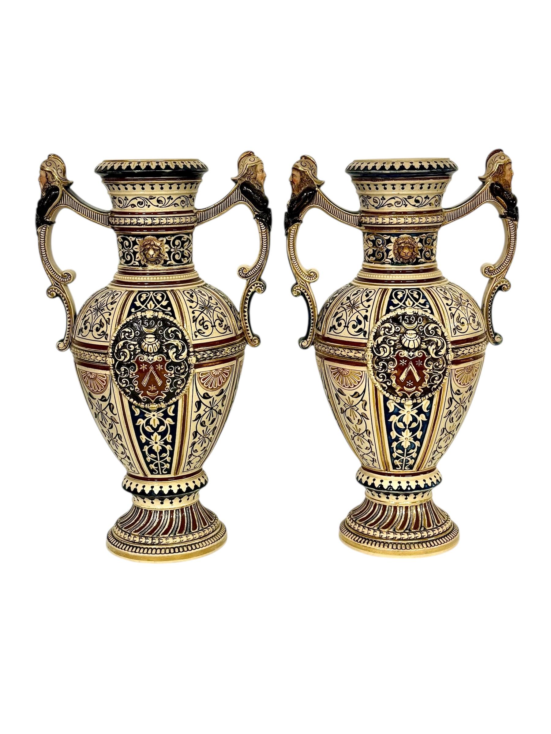 Questa eccezionale coppia di vasi in maiolica finemente dettagliati è un esempio straordinario di design ceramico storicista della fine del XIX secolo, probabilmente realizzato in Germania o in Austria intorno al 1880-1900, ispirato agli stili
