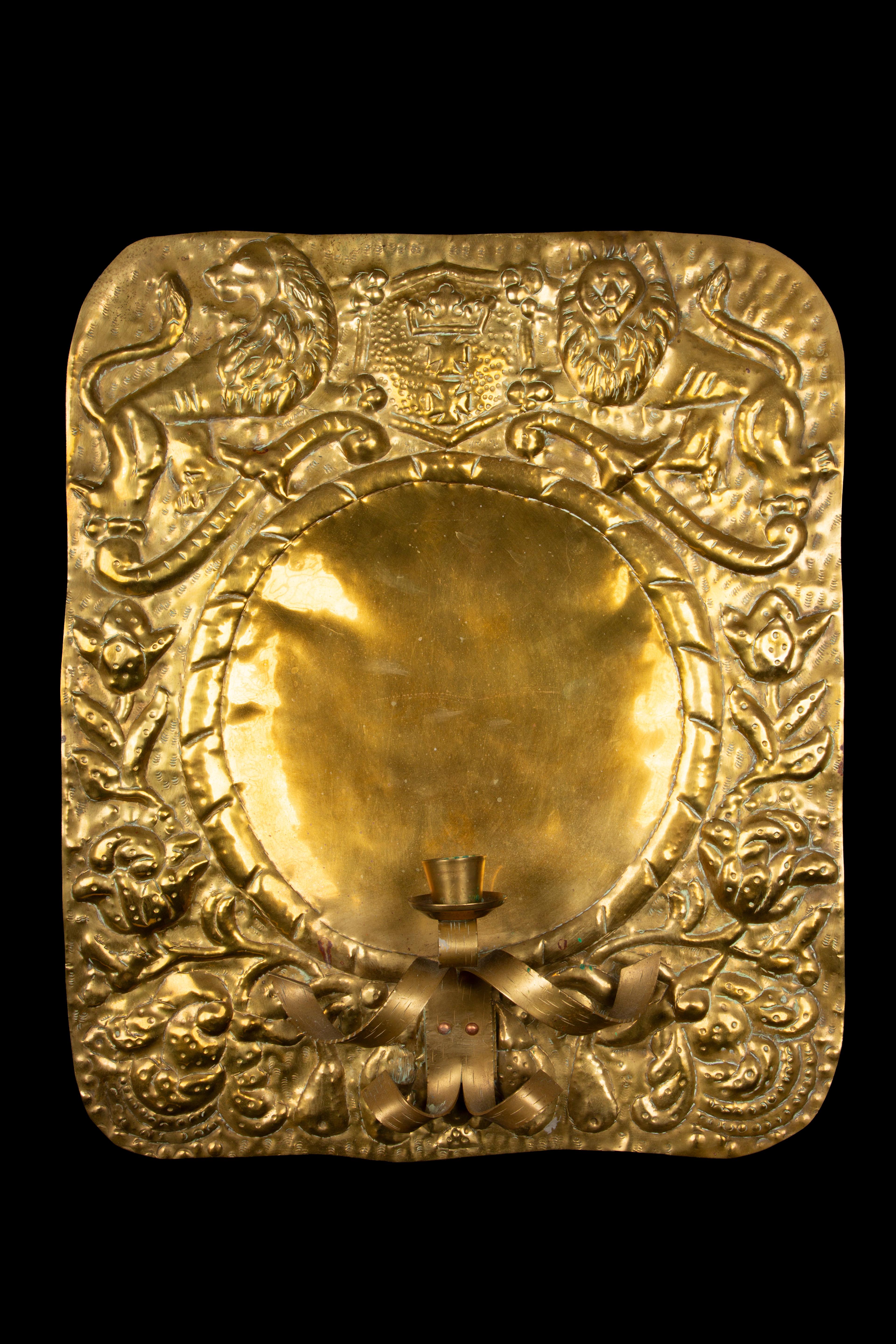 Stunning pair of 19th-century Repousse Brass Candle Wall Sconces, adorned with a meticulously crafted Heraldic Coat of Arms. These exquisite sconces encapsulate the opulence and craftsmanship of the 19th century, when such intricate detailing was